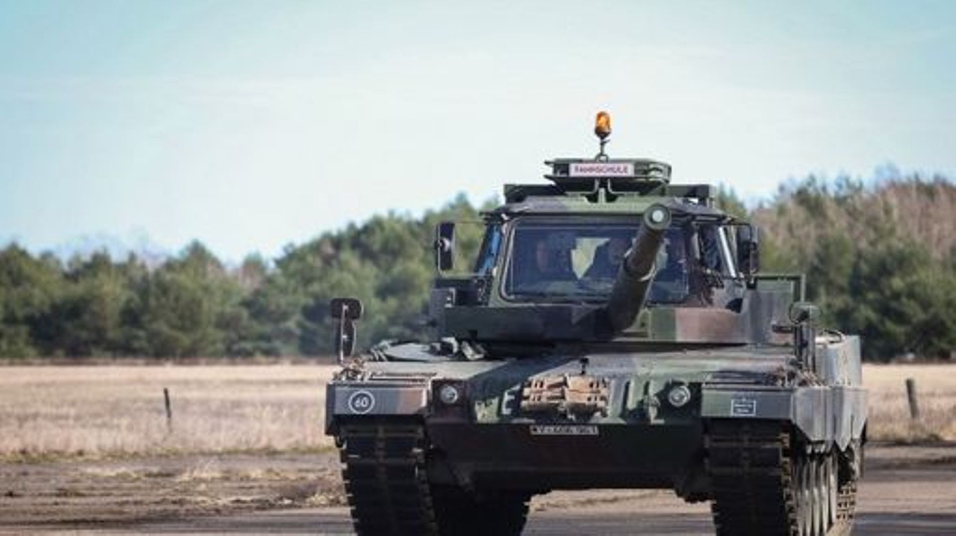 Le ministre allemand de la Défense, Boris Pistorius (G), assis dans un véhicule d’auto-école sur la base d’un char Leopard 2 A4, lors de sa visite aux troupes des forces armées allemandes Bundeswehr sur une zone d’entraînement militaire à Mahlwinkel près 