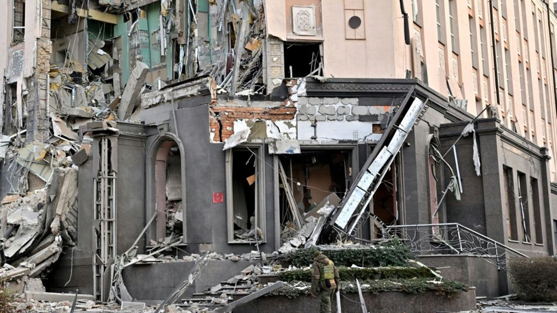 Un militaire ukrainien passe devant un bâtiment en ruines à Kiev après des frappes russes sur plusieurs villes du pays, le 31 décembre 2022