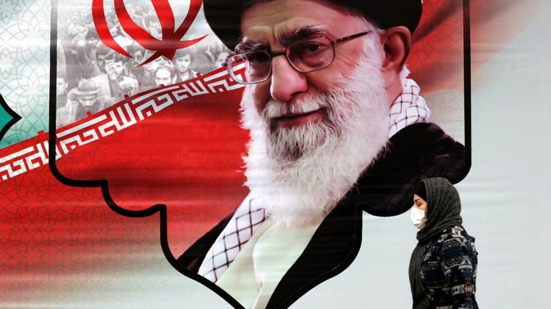 Sur cette photo d'archive prise le 9 mars 2022, une femme iranienne passe devant un panneau publicitaire montrant le guide suprême de l'Iran, l'Ayatollah Ali Khamenei