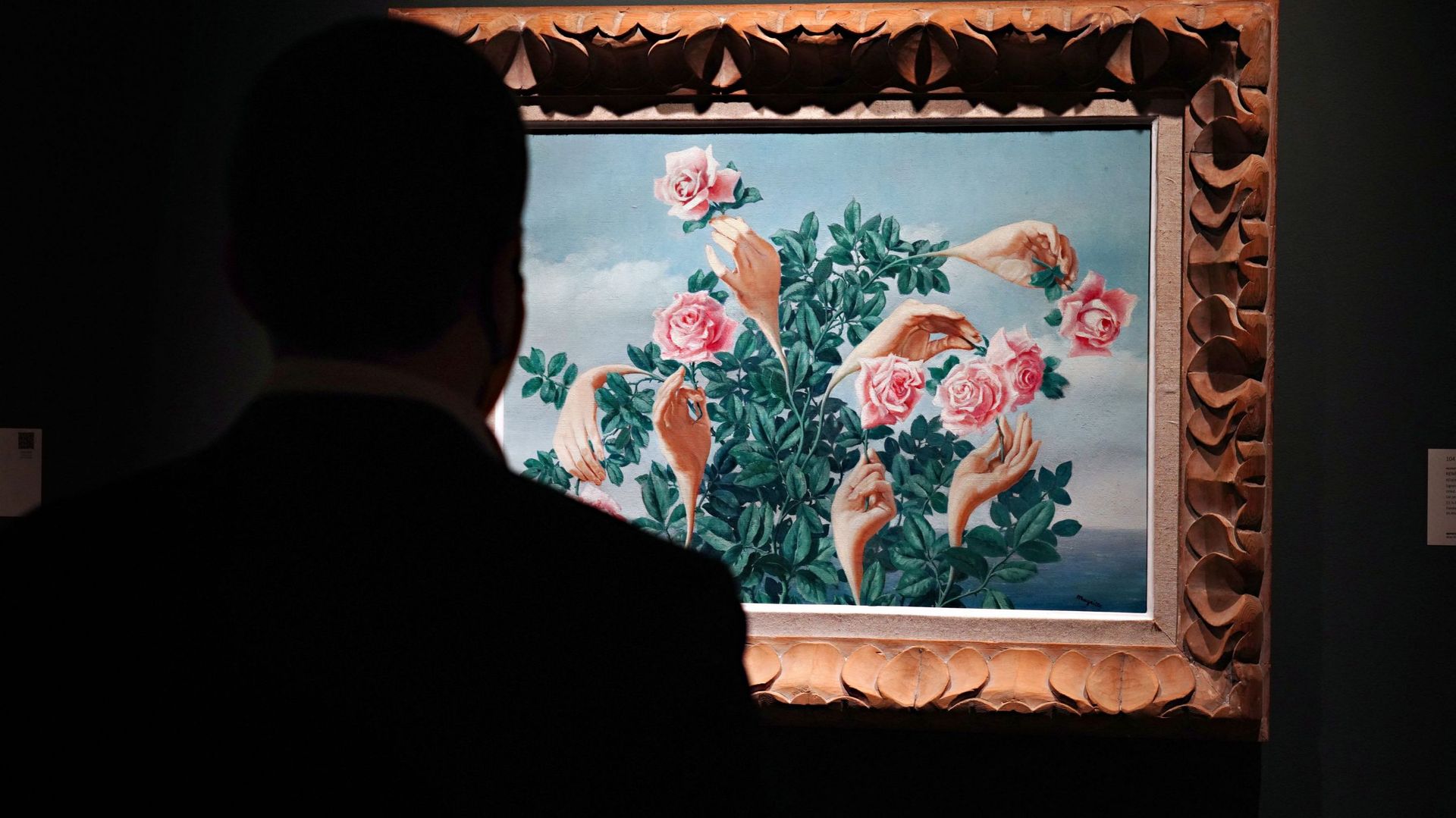 Une personne portant un masque de protection regarde "Rêverie de Monsieur James" de René Magritte lors d'une avant-première de presse de la prochaine vente du soir d'art impressionniste et moderne chez Sotheby's, le 23 octobre 2020 à New York.
