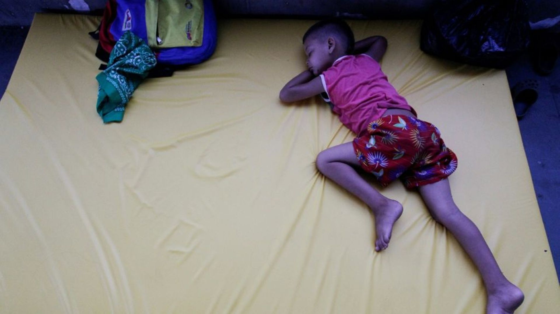 Un petit garçon dort dans une salle de sport aménagée pour accueillir des Vénézuéliens fuyant leur pays, le 22 avril 2020 à Puerto Santander, en Colombie