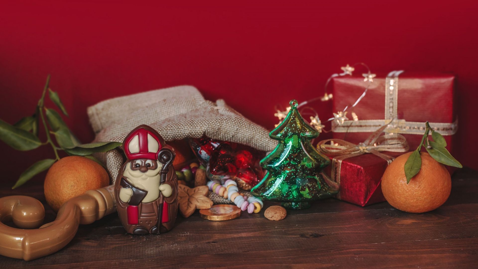 Saint-Nicolas en chocolat avec un petit sapin, des confiseries et des cadeaux