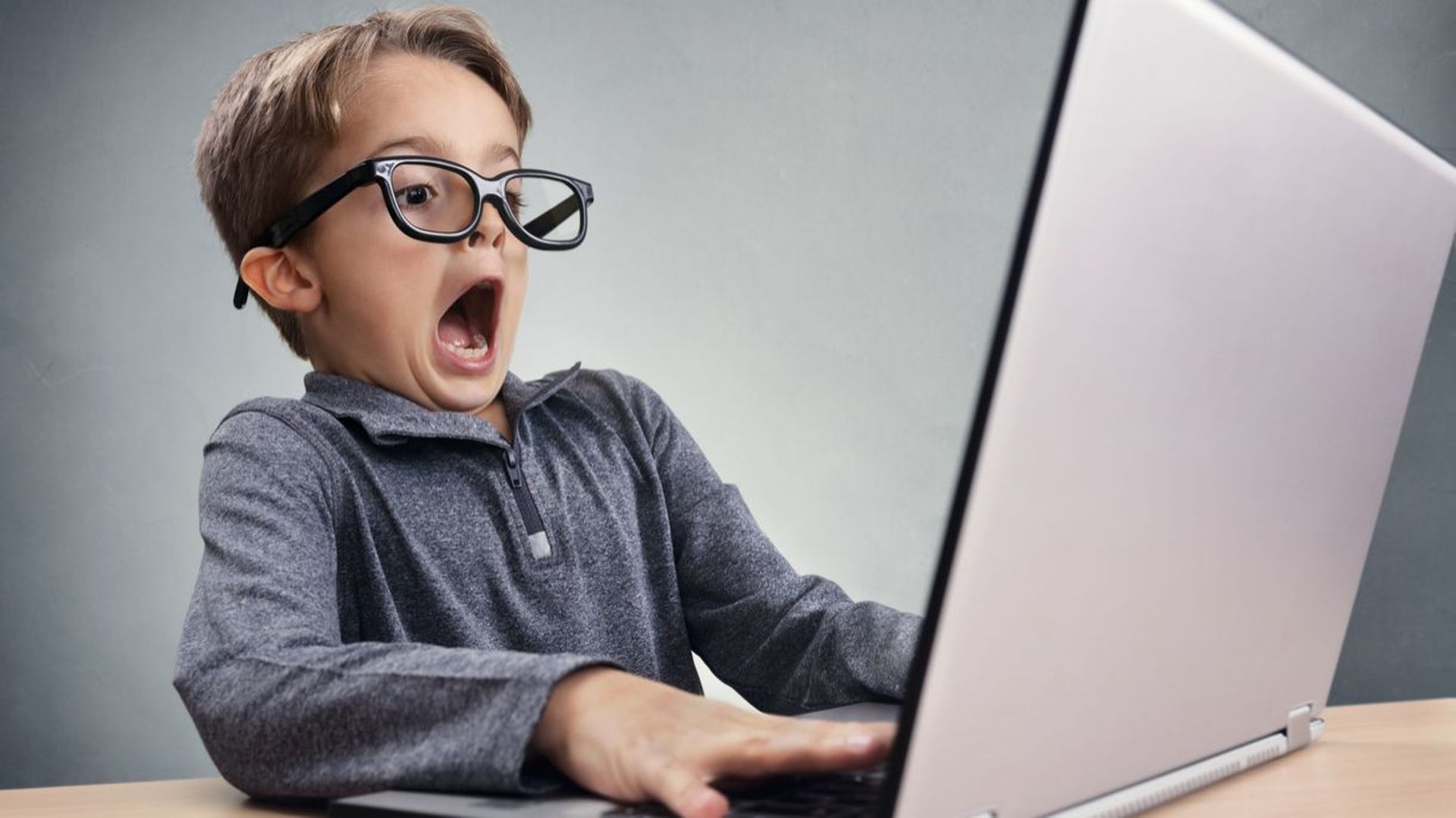 Shocked and surprised boy on the internet with laptop computer
