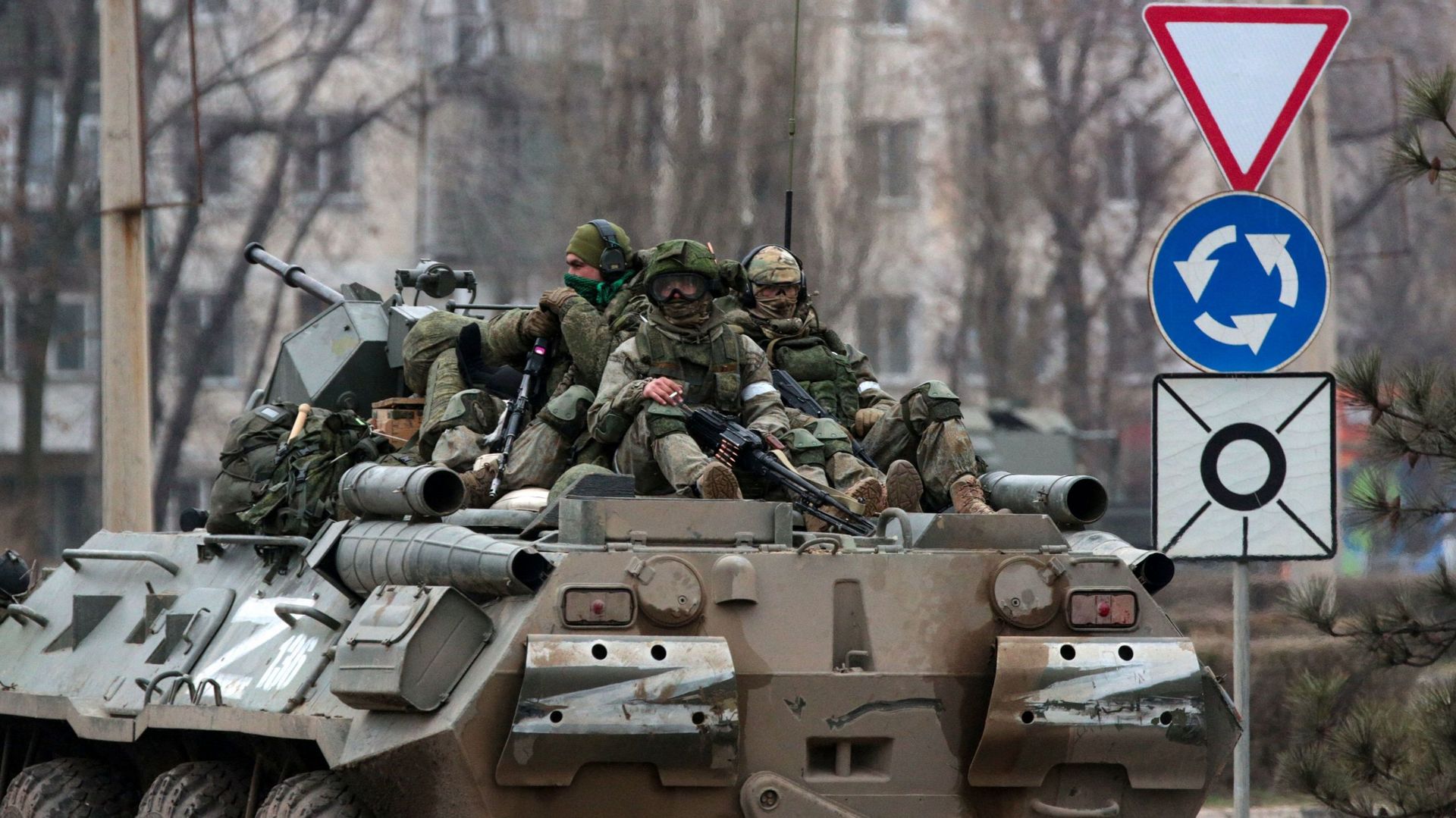 Des militaires montent au sommet d'un véhicule blindé russe à Armyansk, en Crimée. 