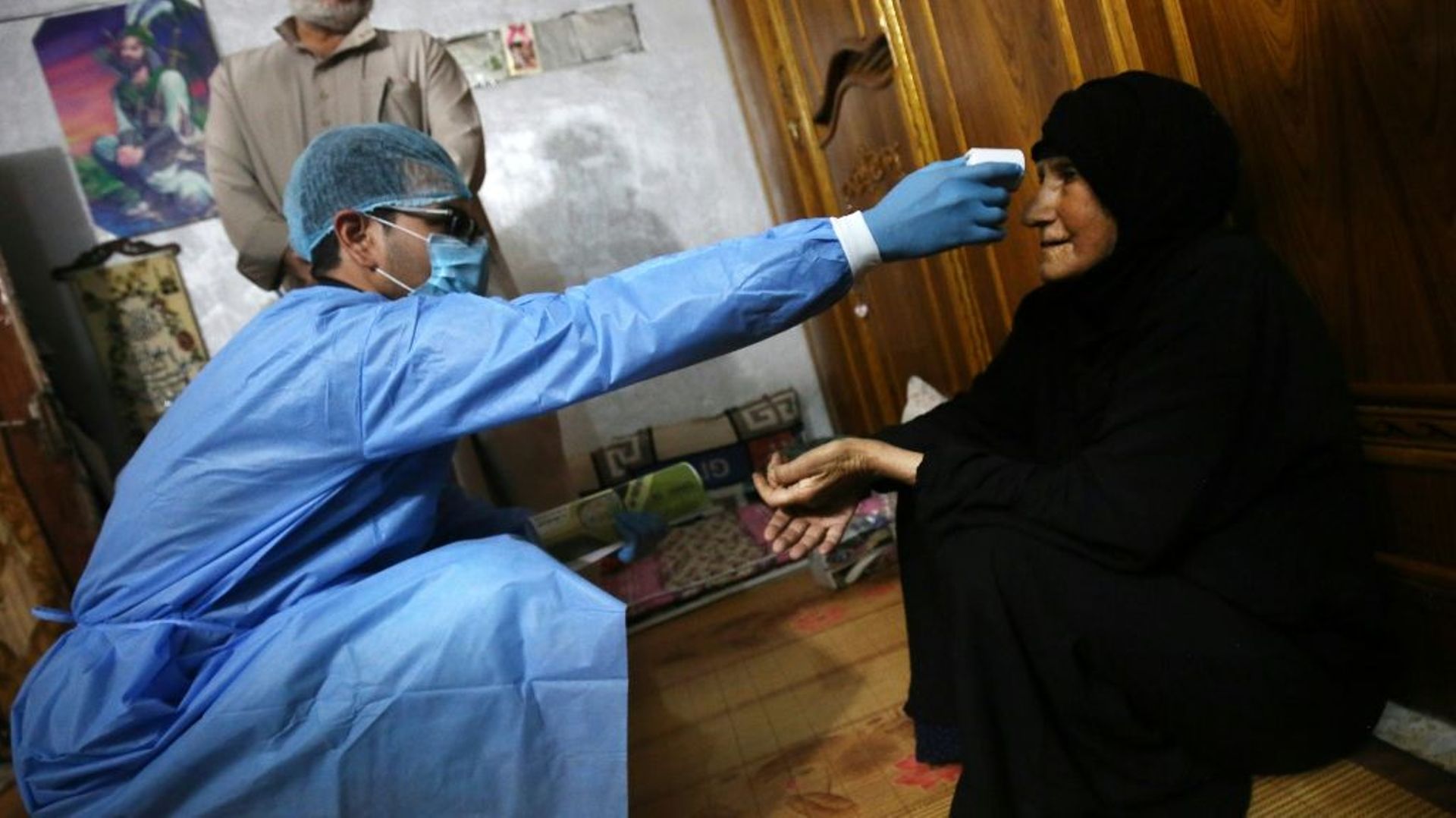 Un médecin prend la température d'une femme, le 2 avril 2020 à Bagdad, en Irak