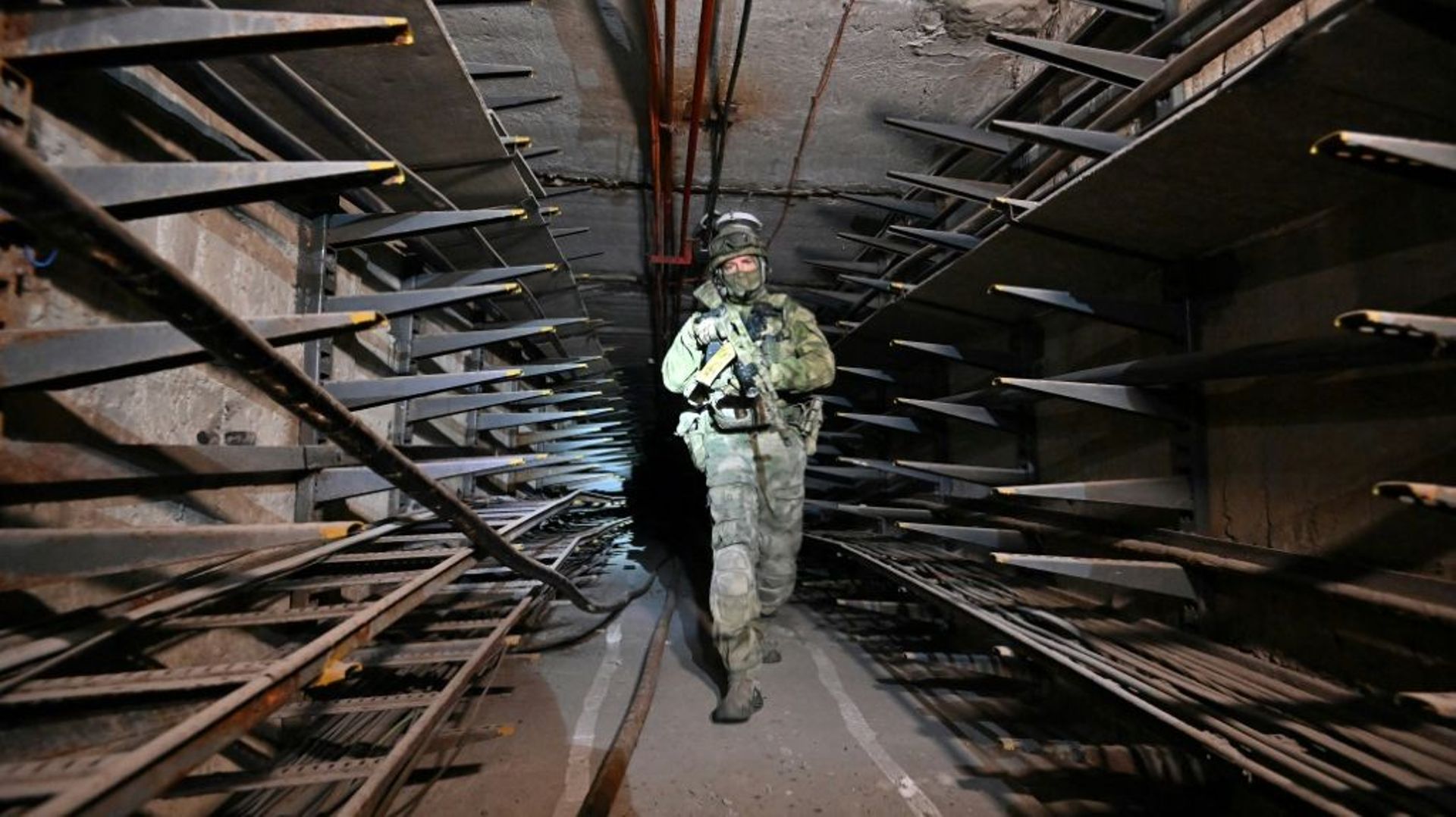 Un soldat russe inspecte un tunnel sous l'aciérie Azovstal de Marioupol, prise à l'Ukraine, le 13 juin 2022