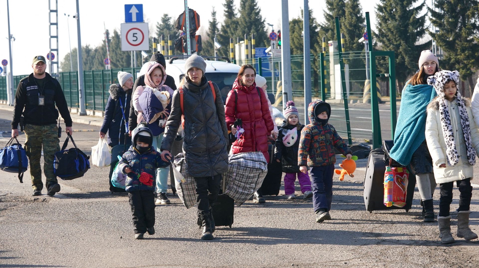 Des femmes et des enfants ukrainien·nes traversent la frontière entre l'Ukraine et la Pologne au poste frontière de Korczowa-Krakovets.