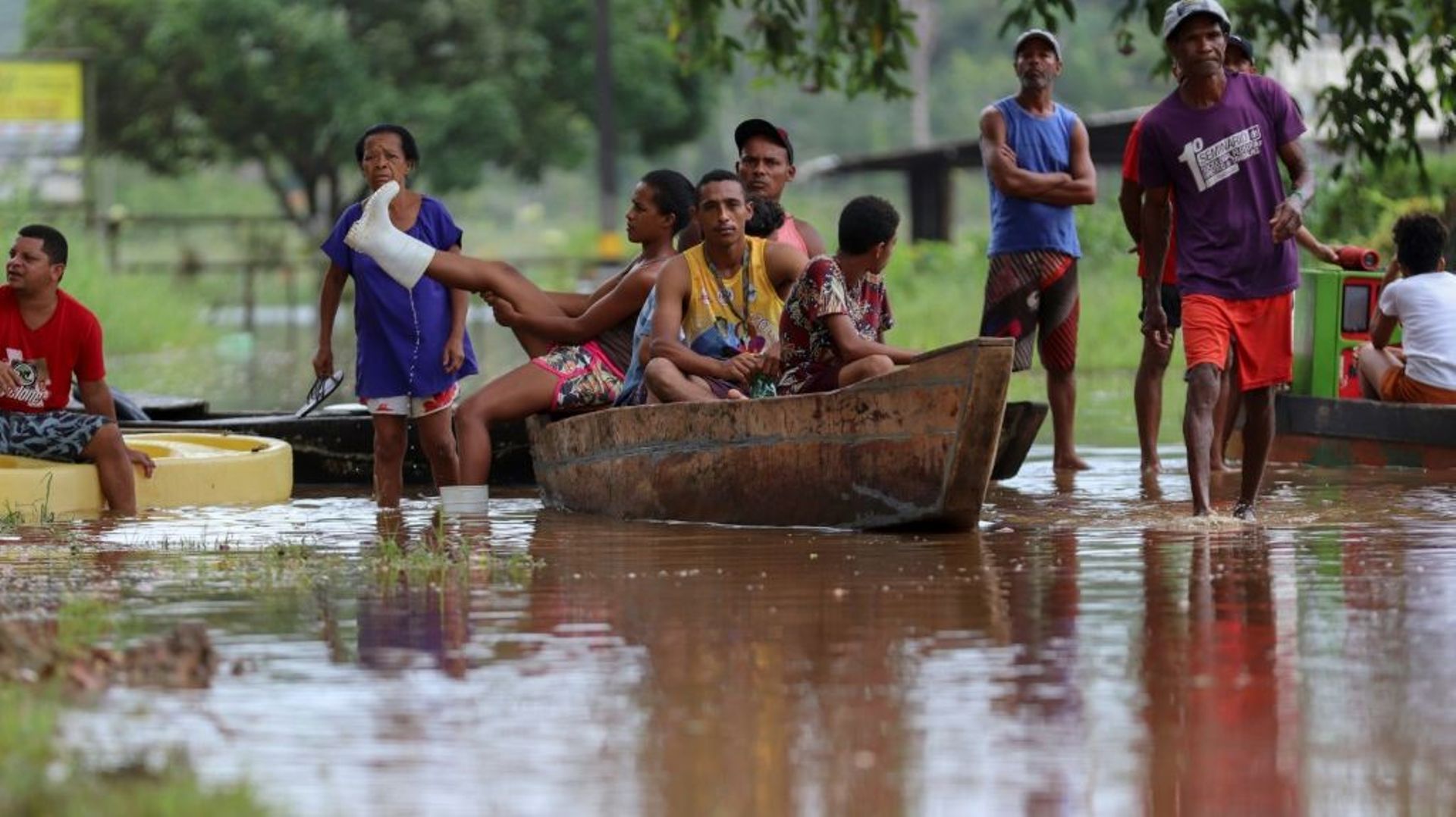 Des habitants utilisent une barque pour traverser un zone inondée dans le quartier Joaia do Atlantico, à Ilheus, dans le sud de l'Etat  brésilien de Bahia