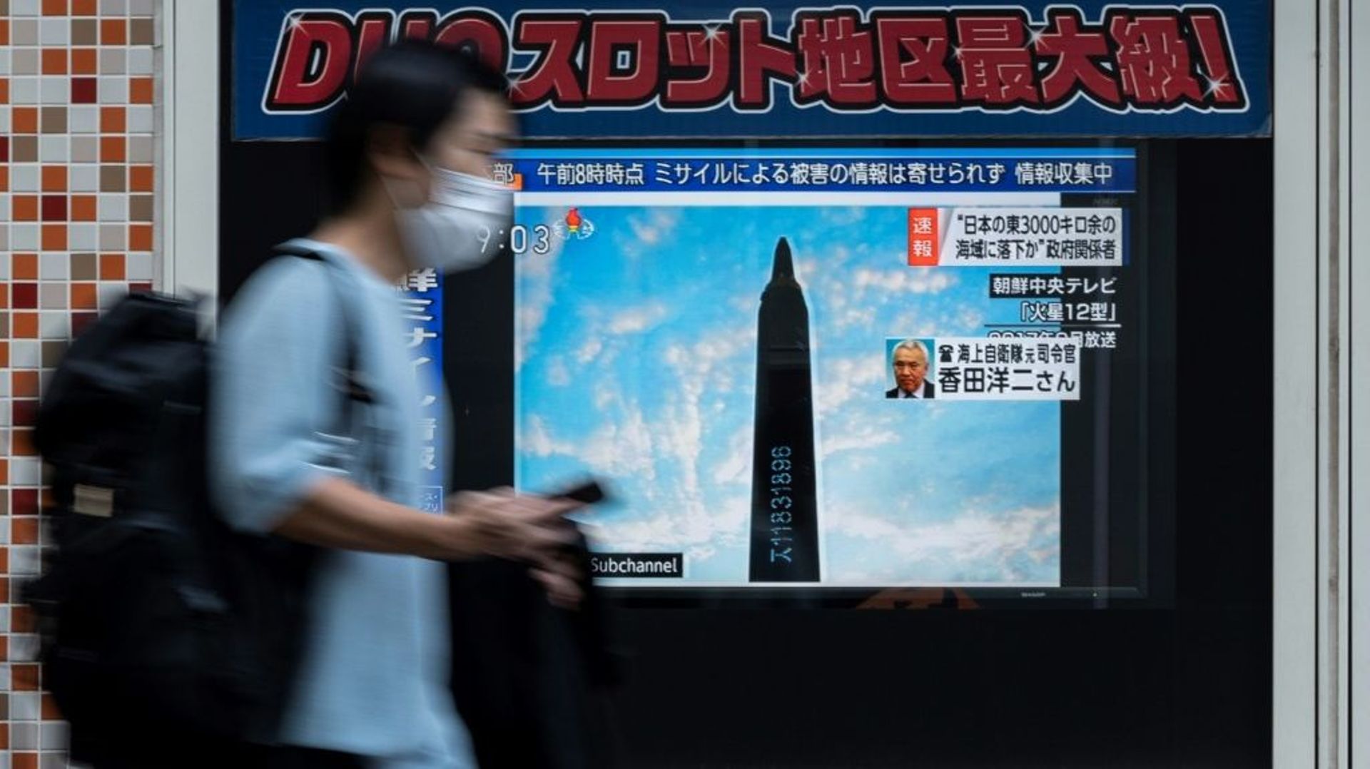 Un homme passe devant un écran de télévision montrant le lancement d'un missile nord-coréen, à Tokyo, le 4 octobre 2022