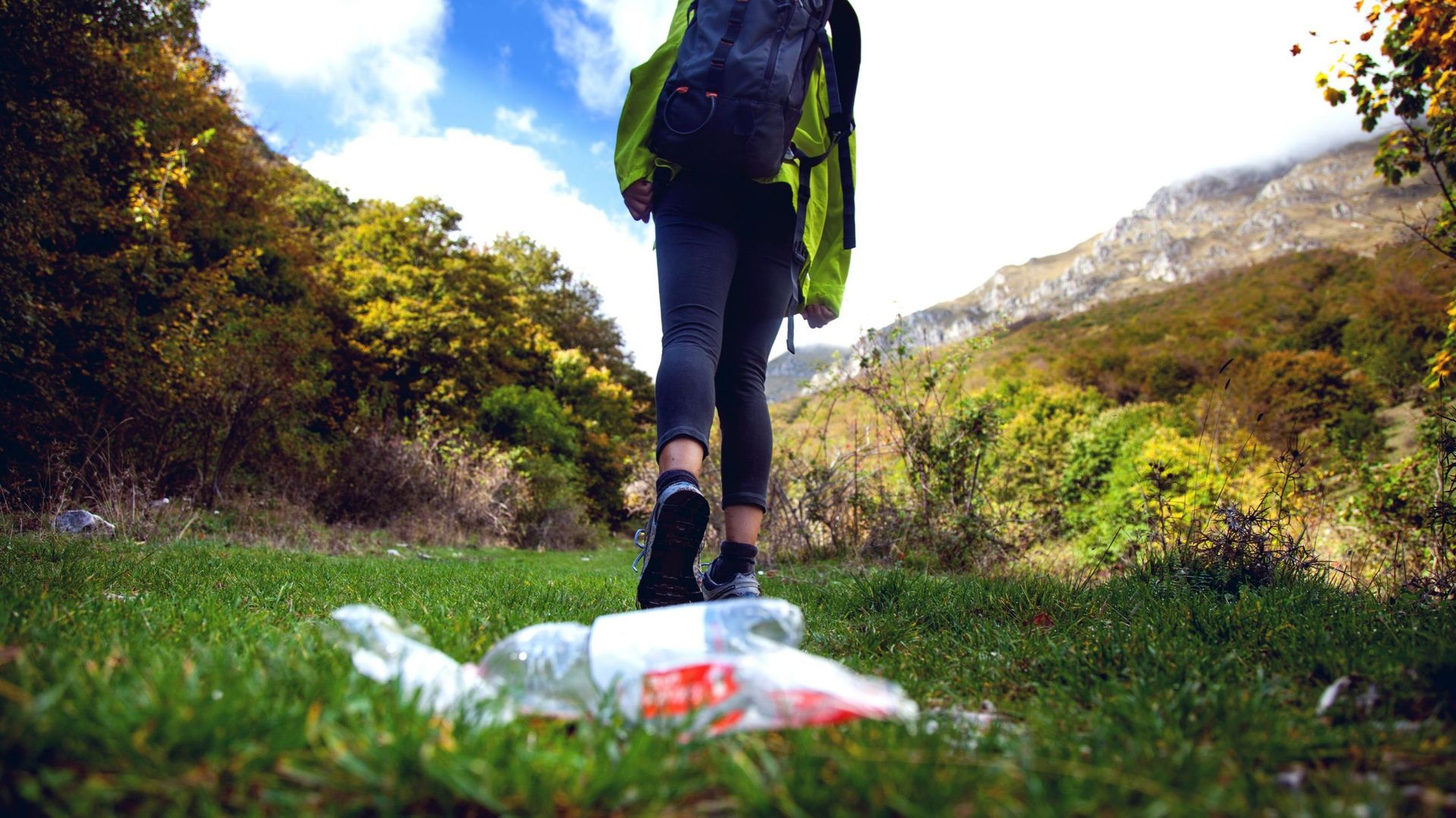 Careless climbers in mountain trashing water bottle on the grass