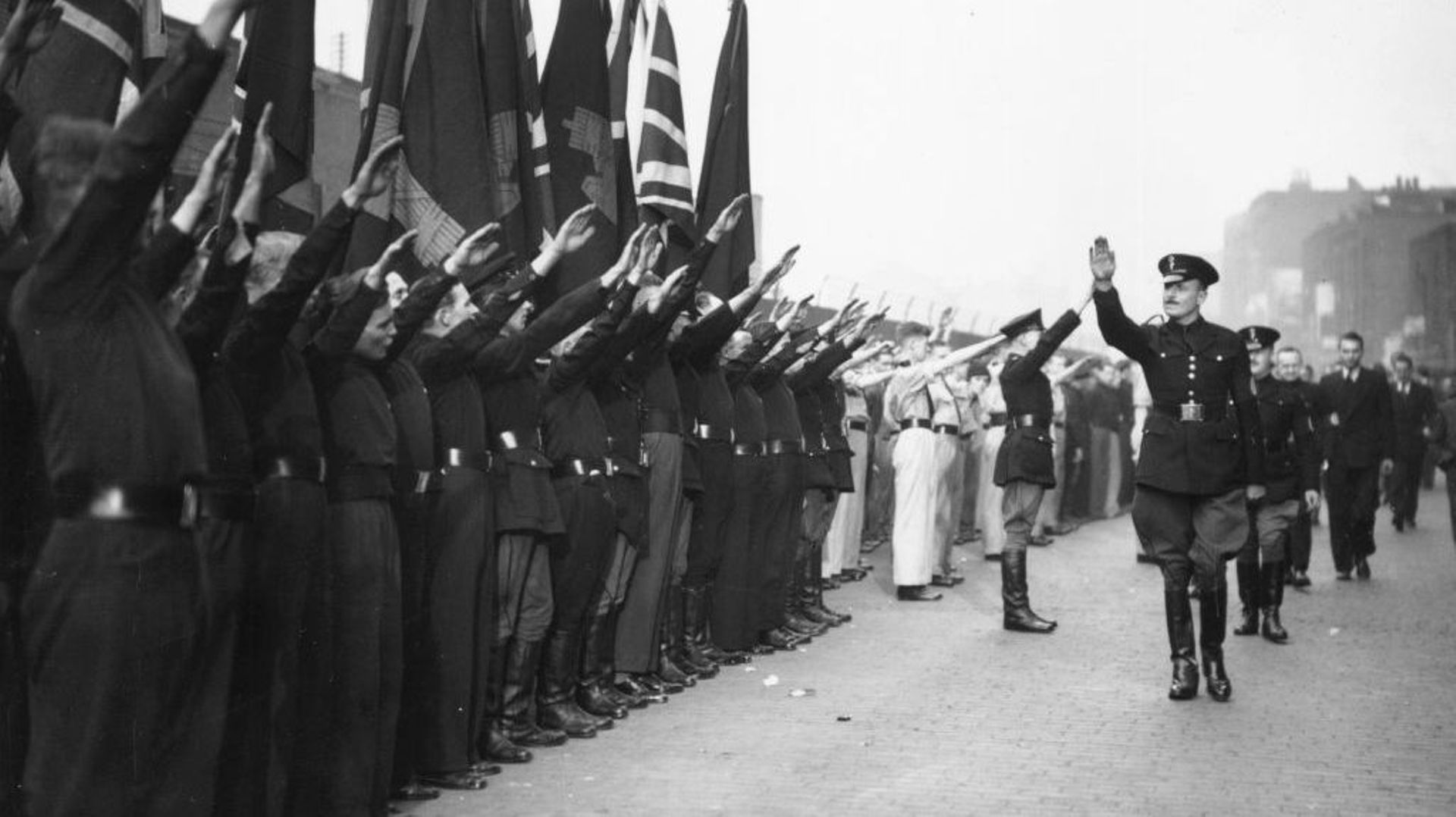 En 1936, Sir Oswald Ernald Mosley retourne le salut nazi lors d'un meeting de la British Union of Fascists à Capel Street à Londres.