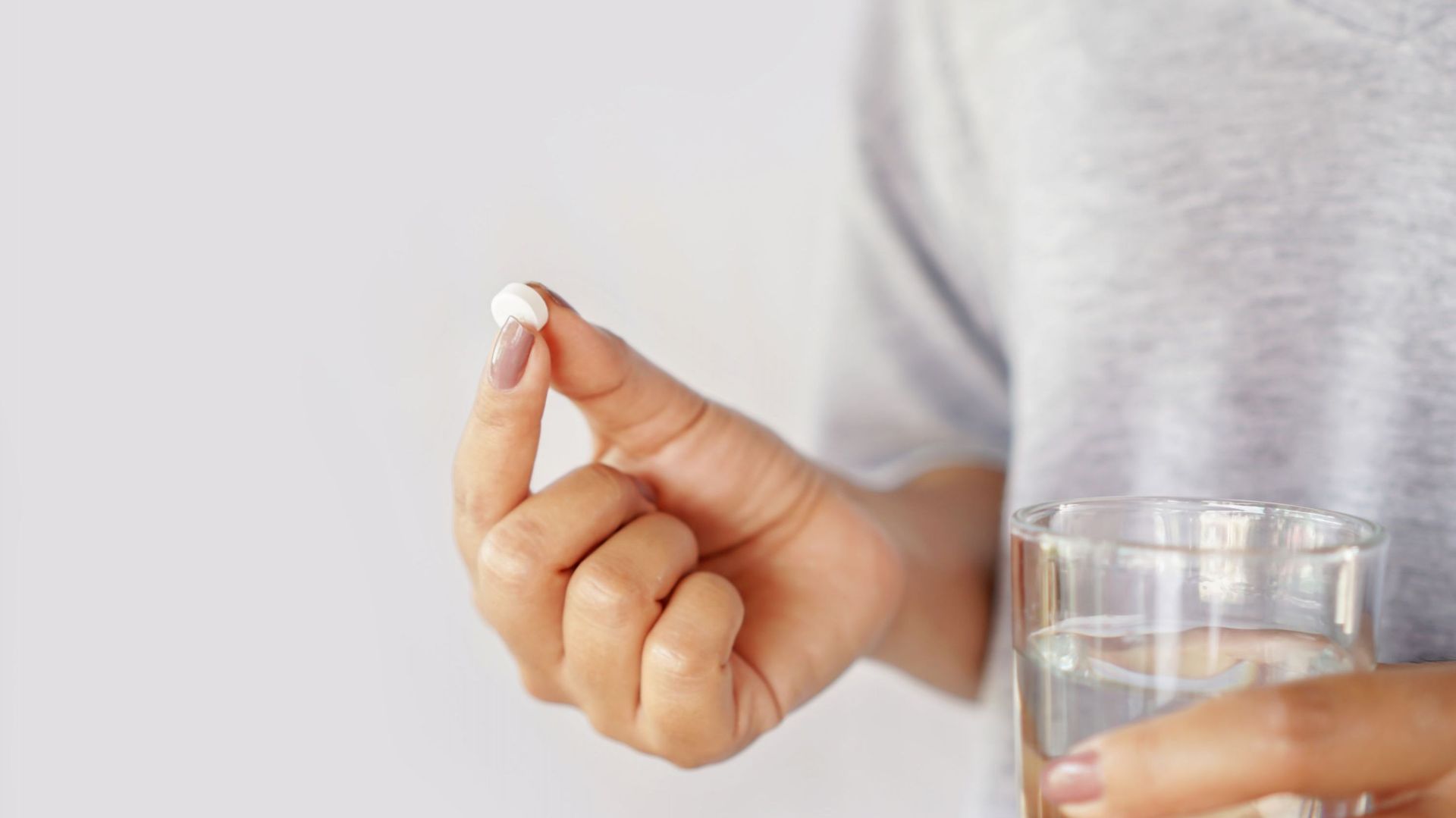Woman Hand Taking Pill With Glass Of Water, Healthcare And Medical Concept