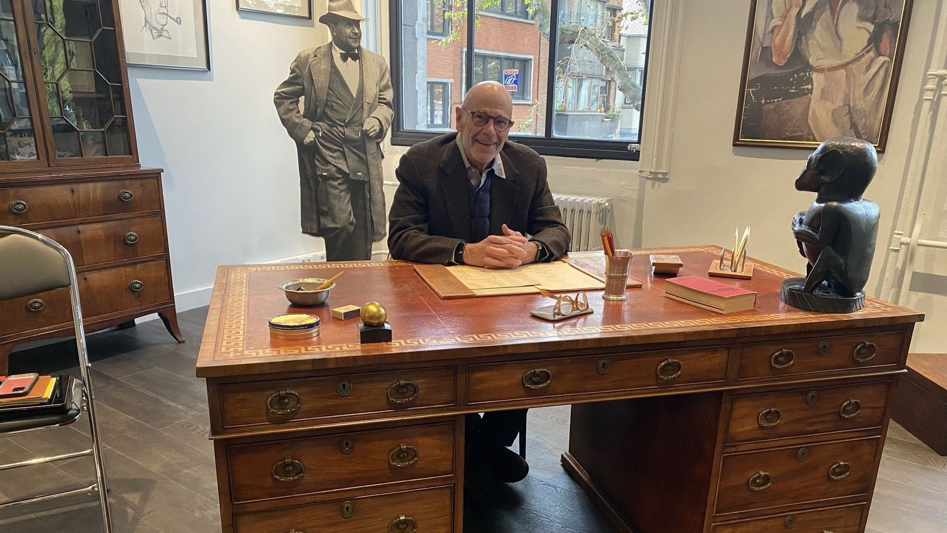 John Simenon assis au bureau de son père conservé au Fonds Simenon