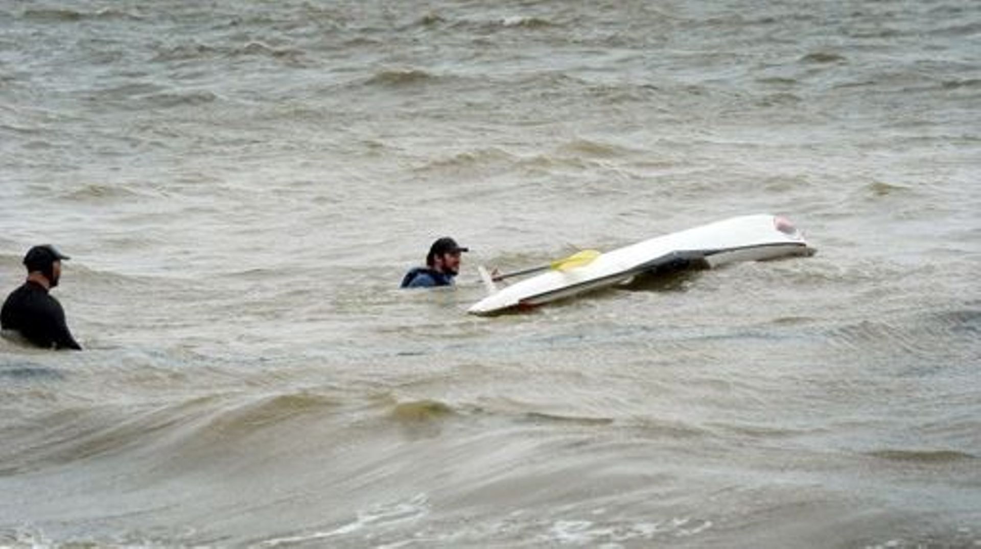 Two men are seen kayaking amid a tropical storm in French Bay, located in the Auckland Region of New Zealand’s North Island on February 13, 2023. Thousands of homes in New Zealand were without power and flights were grounded Monday as a tropical storm las