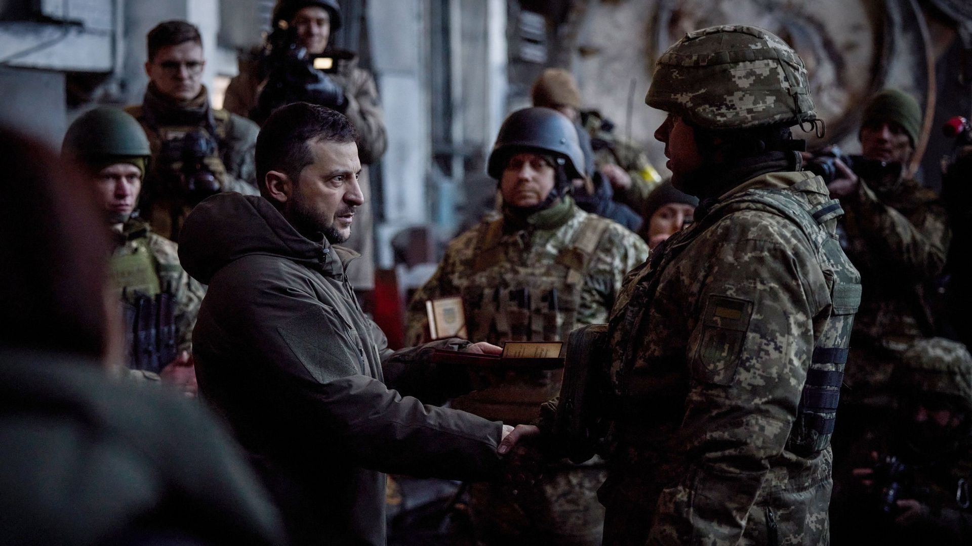Sur cette photo prise et diffusée le 20 décembre 2022 par les services de presse de la présidence ukrainienne, le président Volodymyr Zelensky remet le prix d’État à un soldat lors d’une cérémonie de remise de médailles aux militaires ukrainiens.