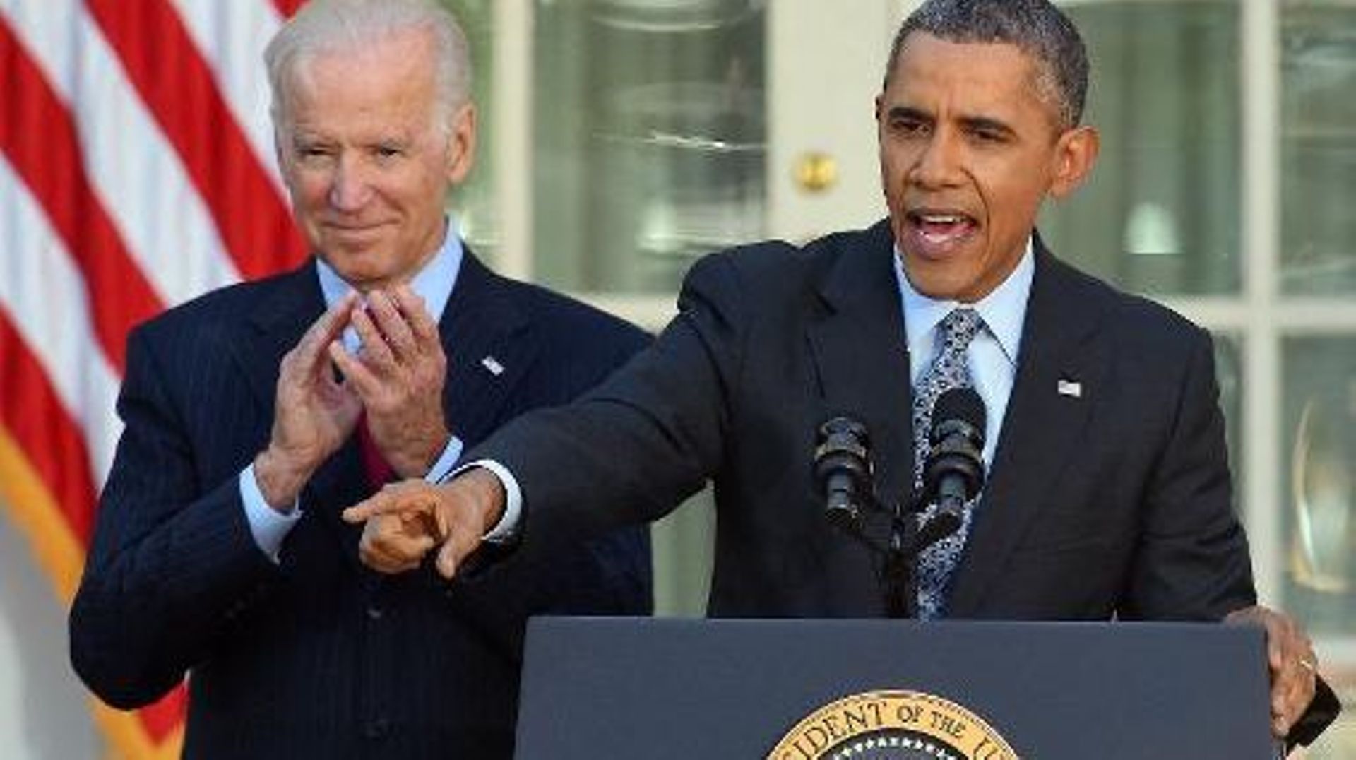 Le président américain Barack Obama, accompagné de son vice-président Joe Biden, se félicite, le 1er avril 2014 à La Maison Blanche à Washington, d'avoir dépassé son objectif de 7 millions d'Américains ayant souscrit à une couverture maladie 