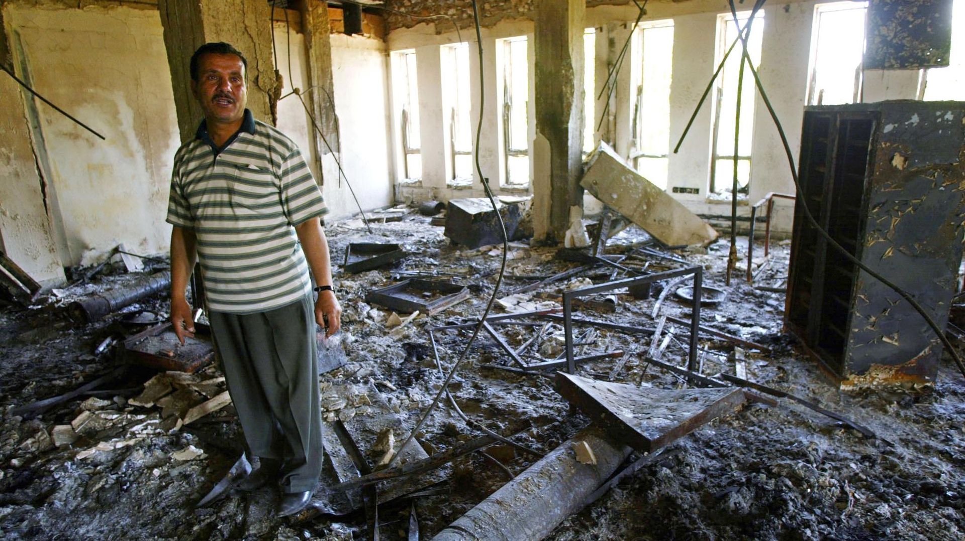 Le directeur du centre informatique de l'université de Mossoul posant au milieu des décombres du centre qui a été pillé puis incendié. 