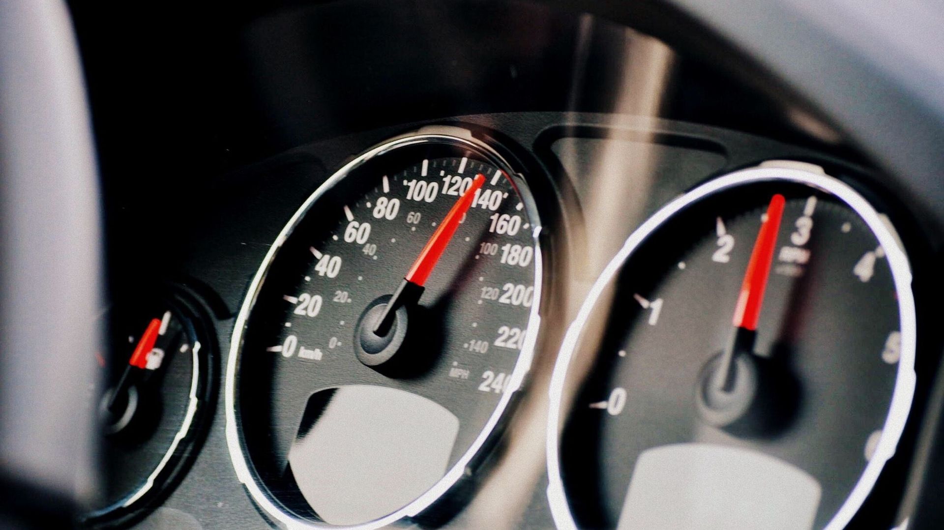 Indicateur de vitesse et jauge de carburant au tableau de bord d'une voiture.