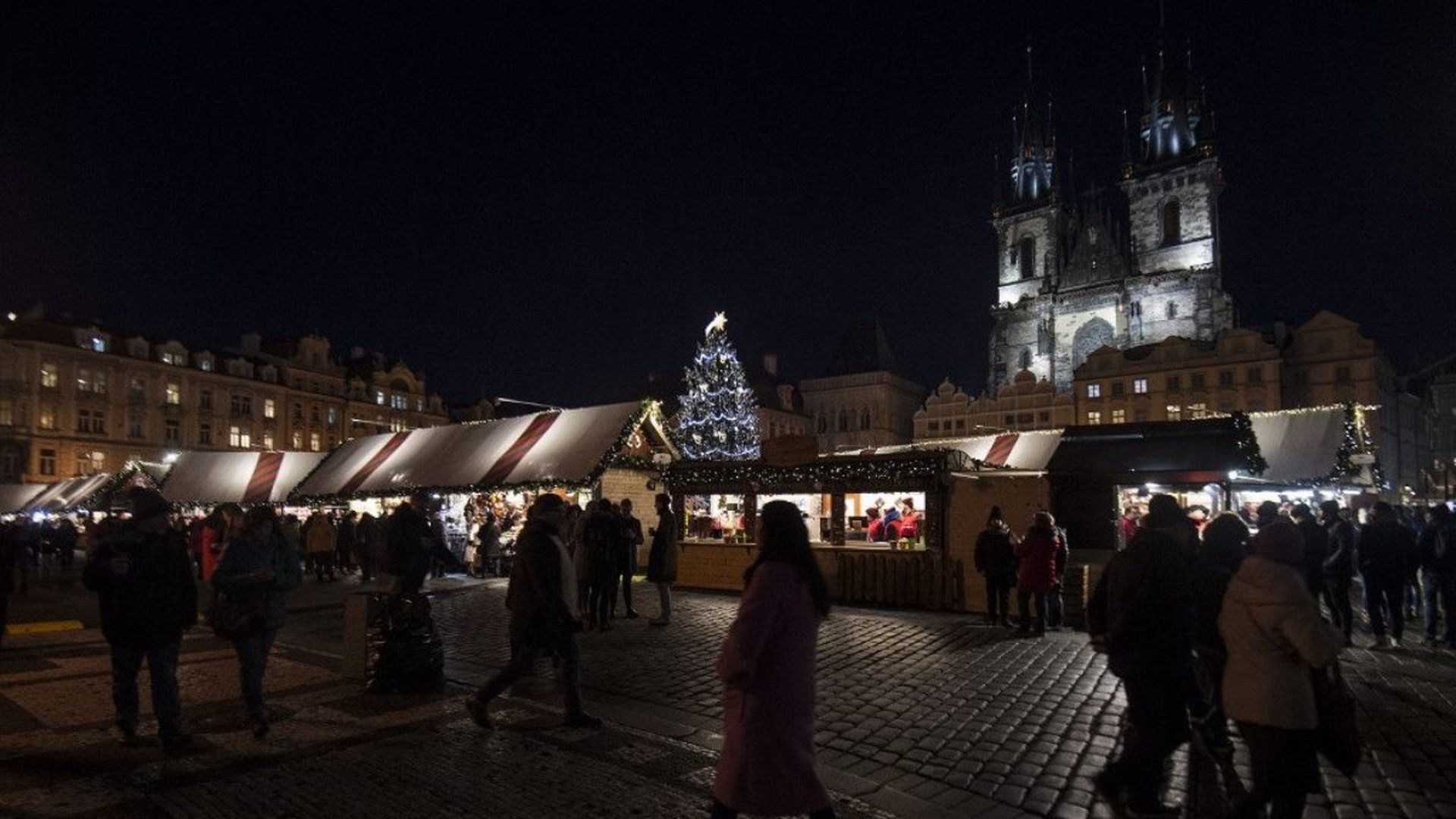 Une photo prise le 4 décembre 2019 montre des personnes passant devant des stands sur un marché de Noël sur la place de la vieille ville de la capitale tchèque à Prague.