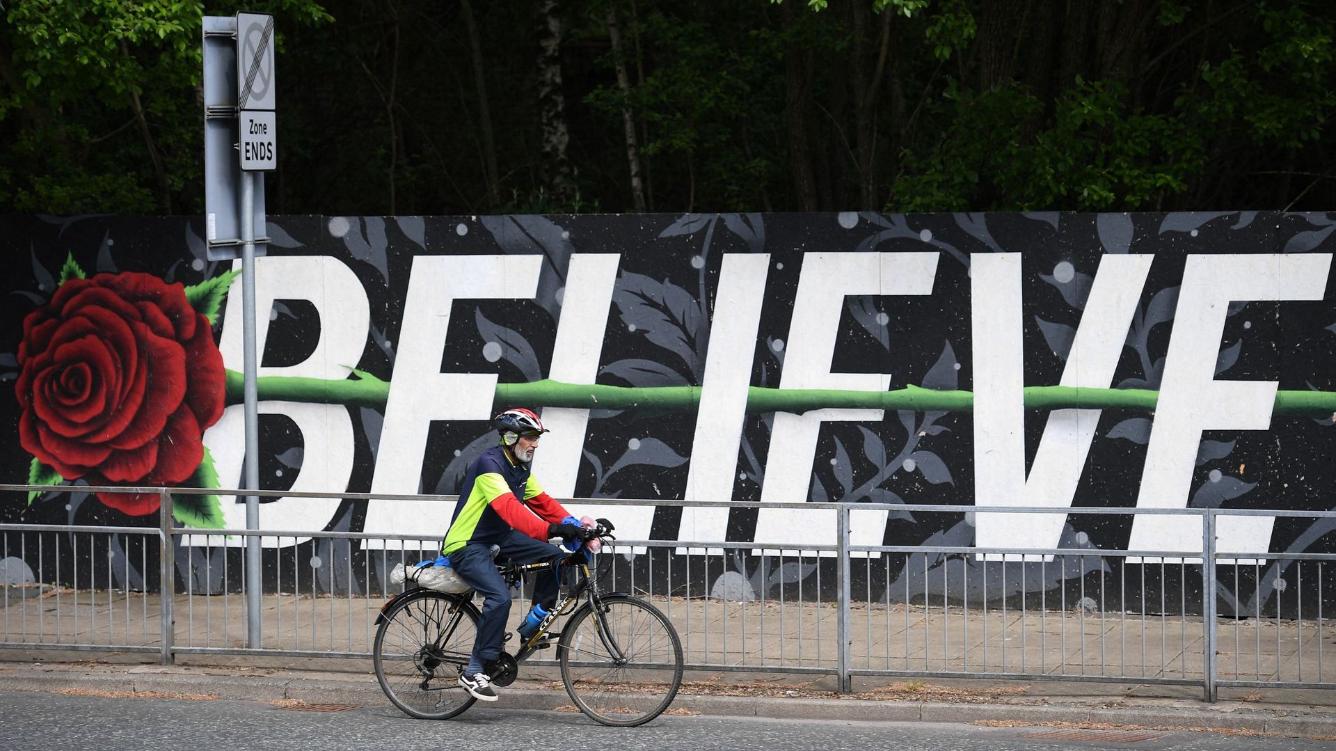 Cycliste devant une fresque représentant une rose (symbole du Lancashire) et le mot "Believe" ("Croire") à Blackburn le 16 juin.