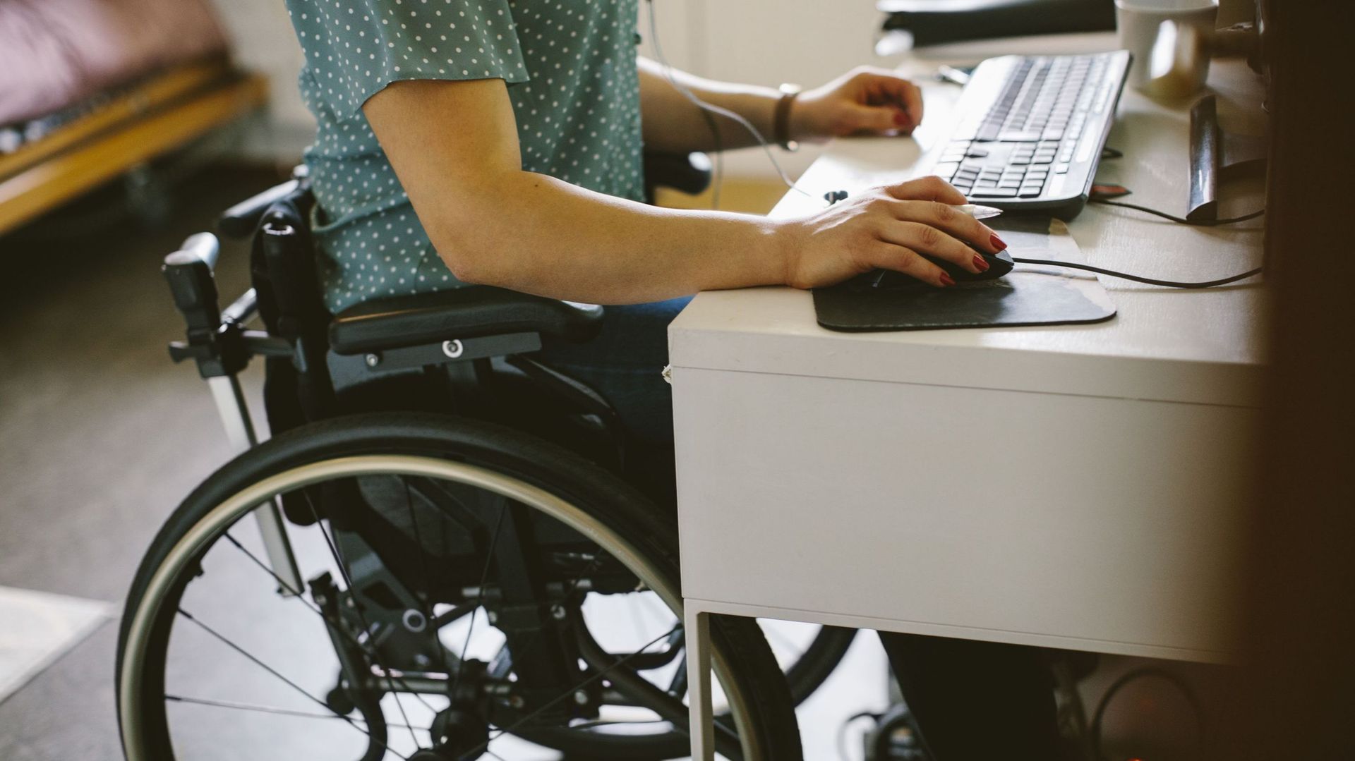 Midsection of young disabled woman using computer at home