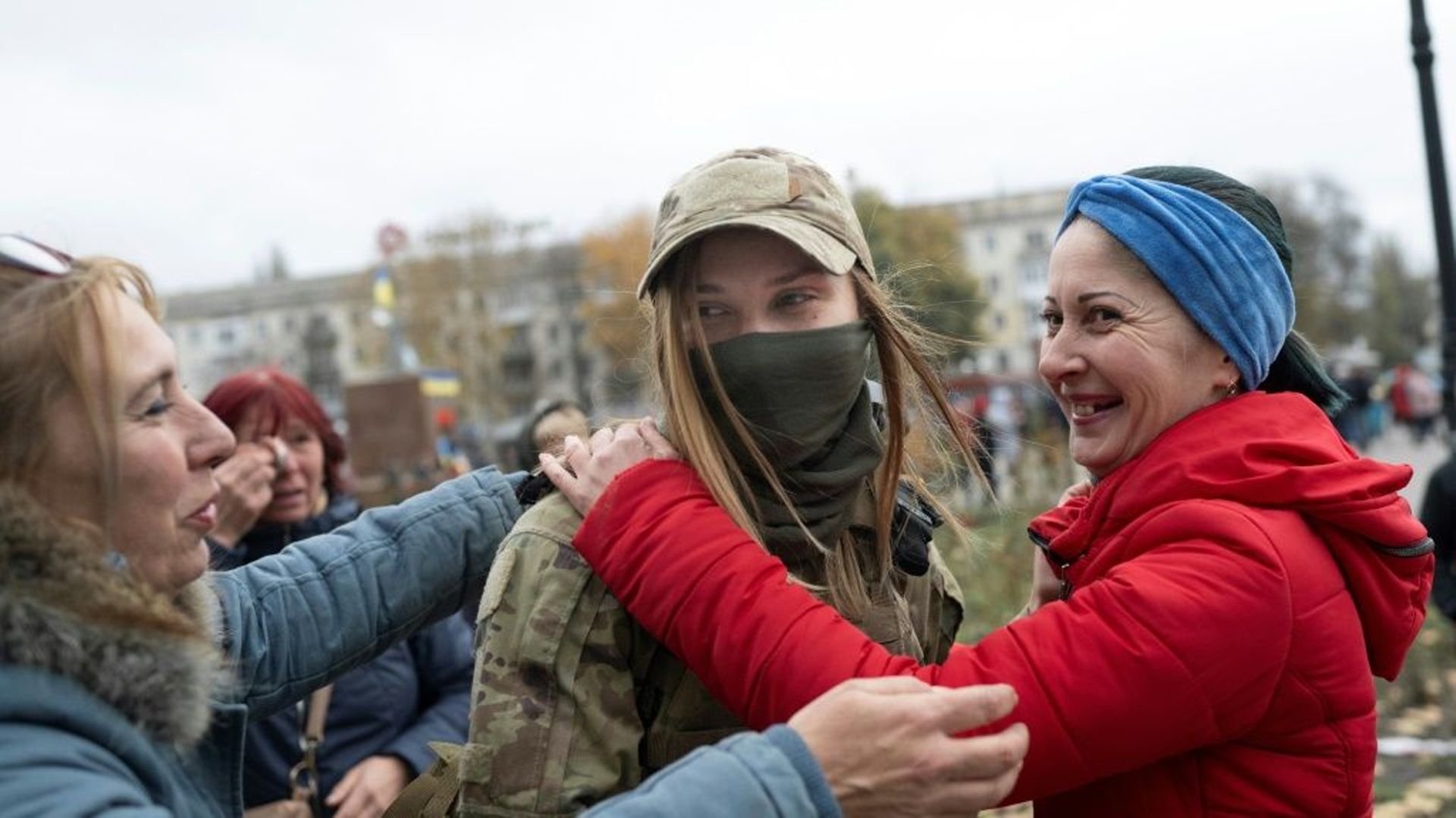 Deux habitantes félicitent une militaire ukrainienne à Kherson, le 13 novembre 2022