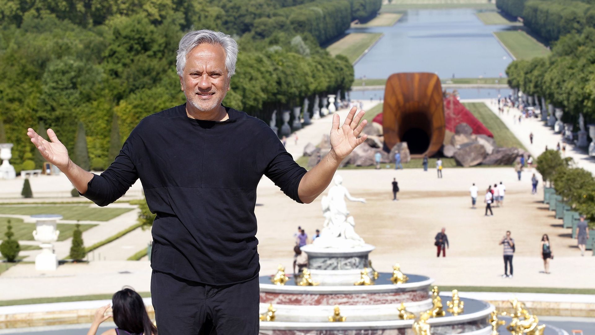 L’artiste contemporain britannique d’origine indienne Anish Kapoor pose devant son œuvre nommée 'Dirty Corner' lors du vernissage de l’exposition de ses œuvres dans les jardins du Château de Versailles, le 5 juin 2015, à Versailles, France.
