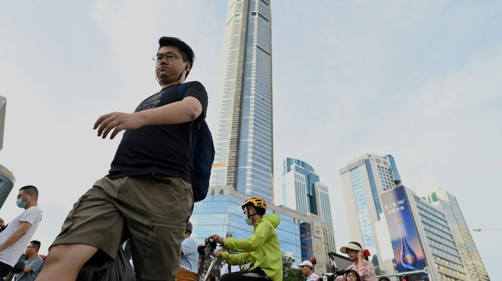 Des gens passent devant le gratte-ciel SEG Plaza, temporairement fermé, dans la ville de Shenzhen (sud de la Chine), le 24 mai 2021