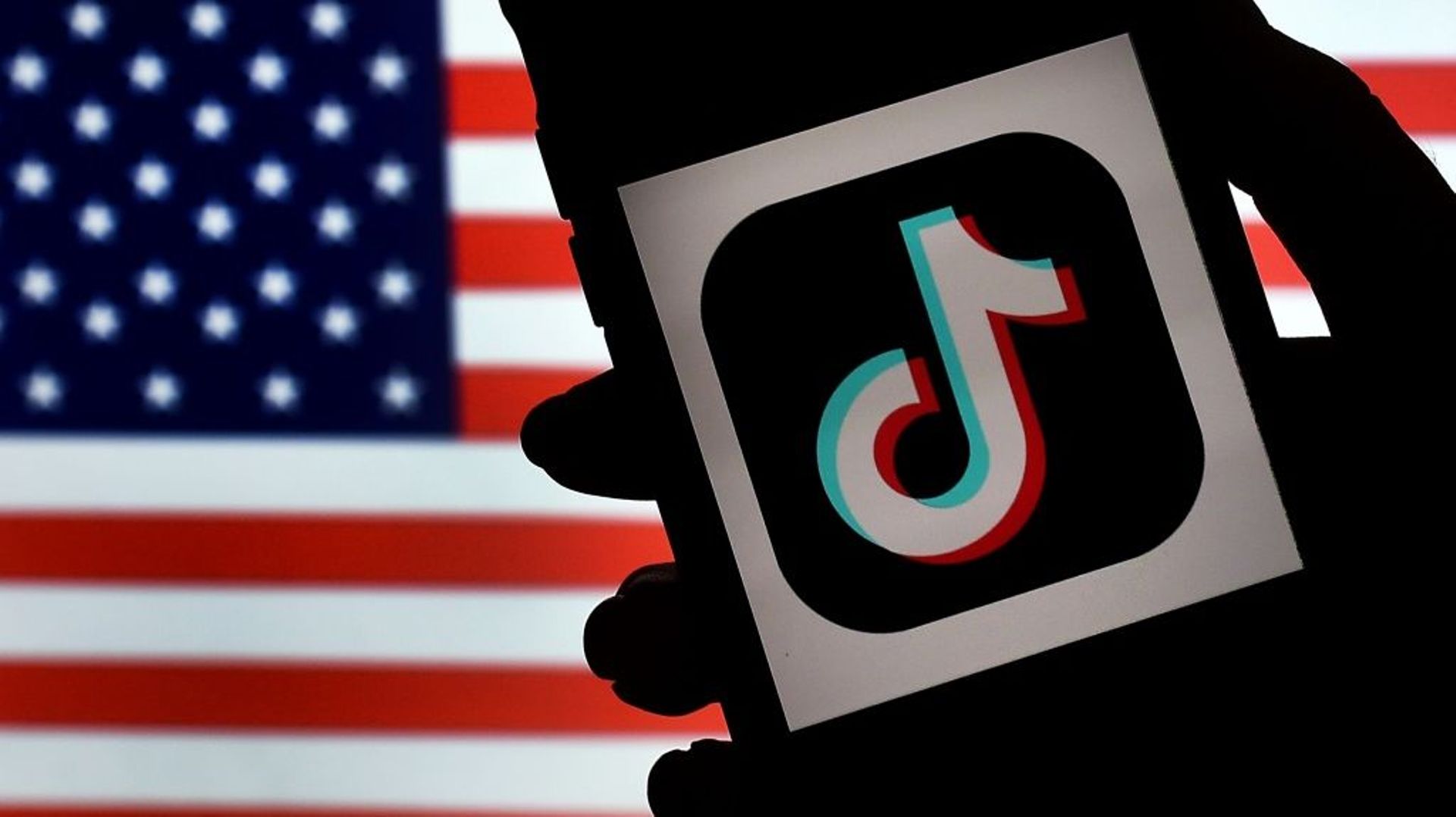 Un smartphone avec le logo de TikTok devant le drapeau américain, à Arlington (Virginie) le 3 août