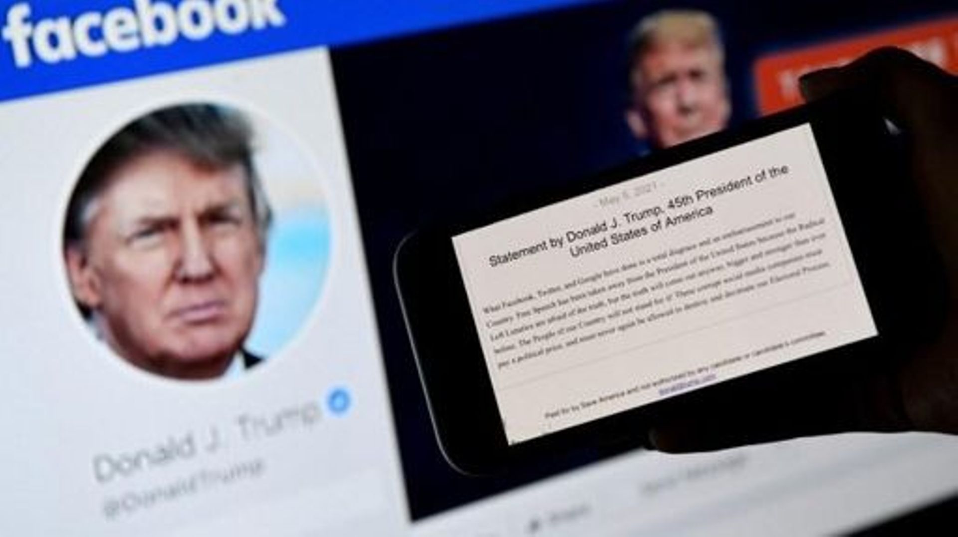 In this photo illustration, a phone screen displays the statement of former US President Donald Trump on his Facebook page background, on May 5, 2021, in Arlington, Virginia. Donald Trump said May 5, 2021 it was a total disgrace for online giants to insti