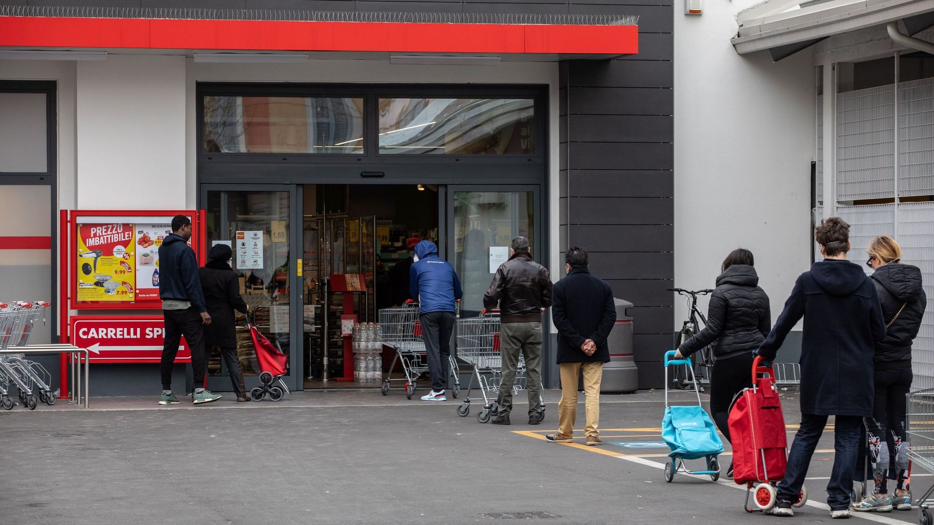 Par mesure de sécurité, les gens gardent leurs distances lorsqu’ils font la file pour faire leurs courses dans un supermarché le 11 mars 2020 à Milan, en Italie.
