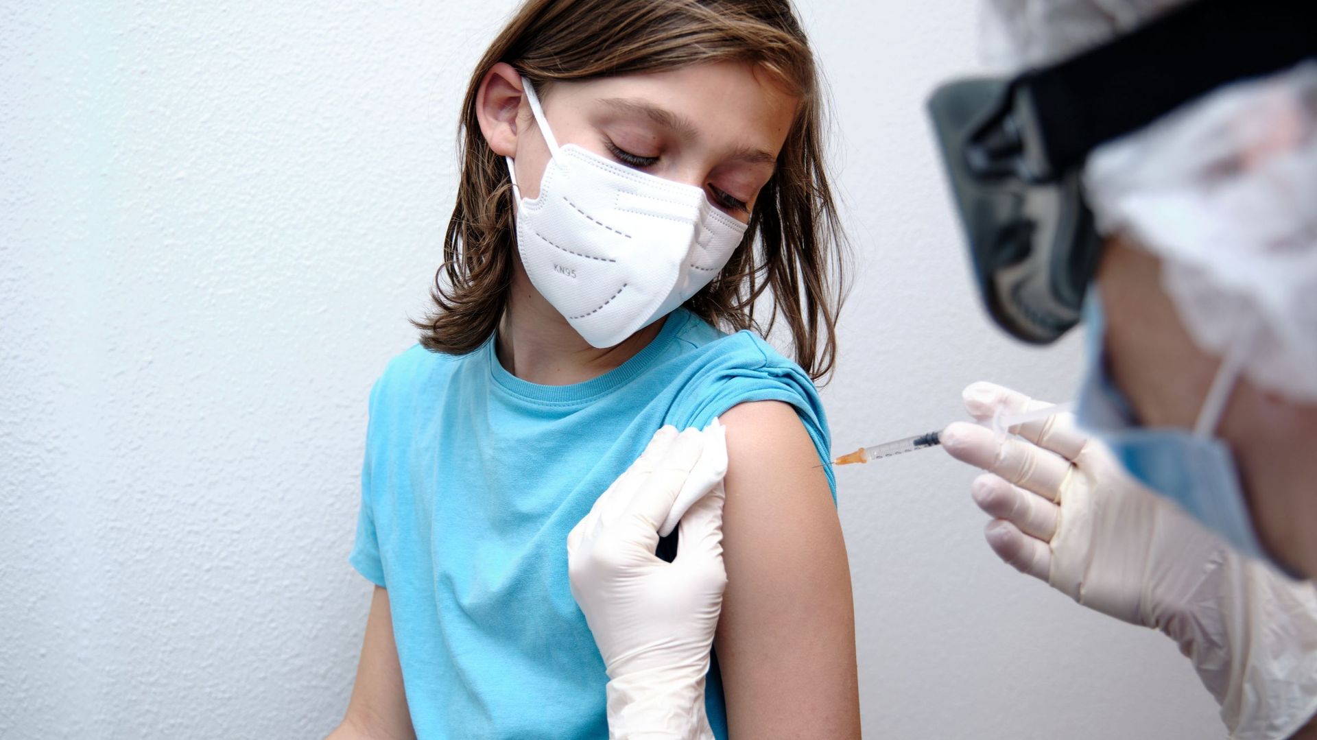 Female doctor giving Covid-19 vaccine to a boy