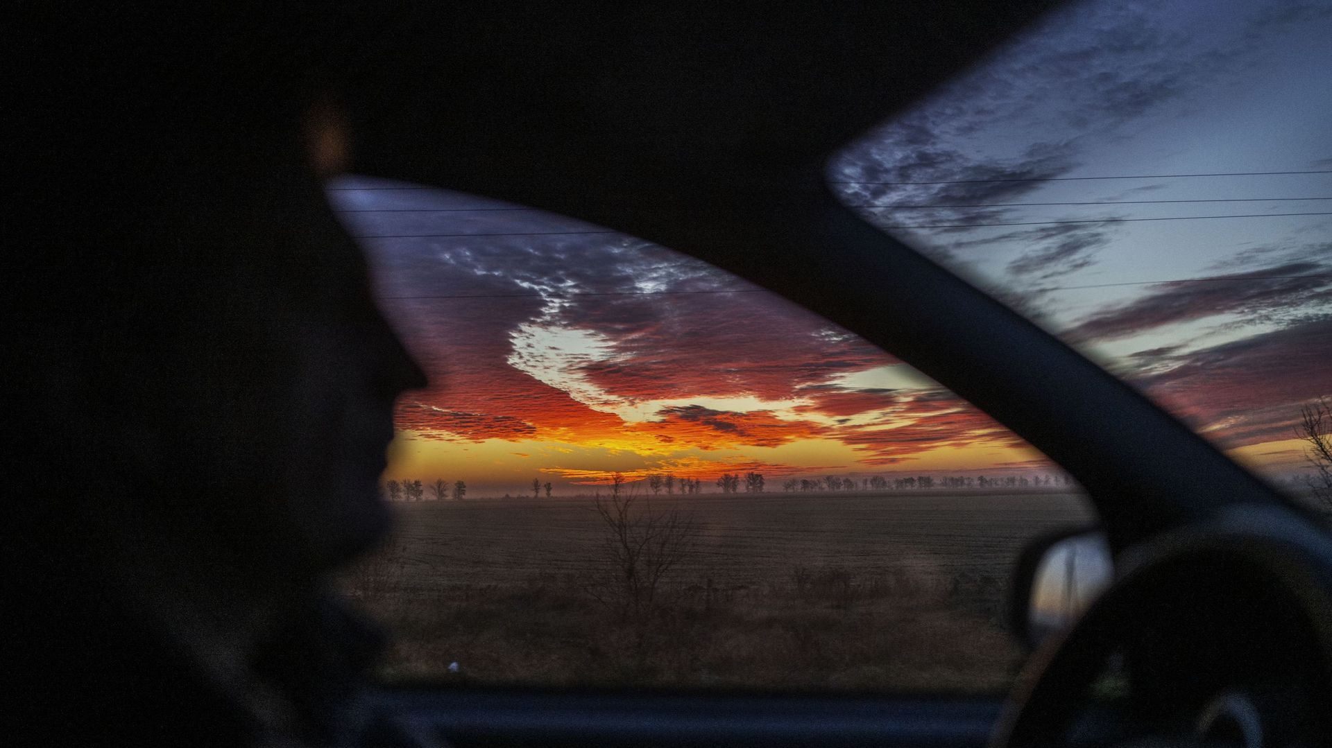 Cette photo prise le 14 novembre 2022 montre un ciel matinal au-dessus de la route entre Kherson et Mykolaiv nouvellement libérés en Ukraine.