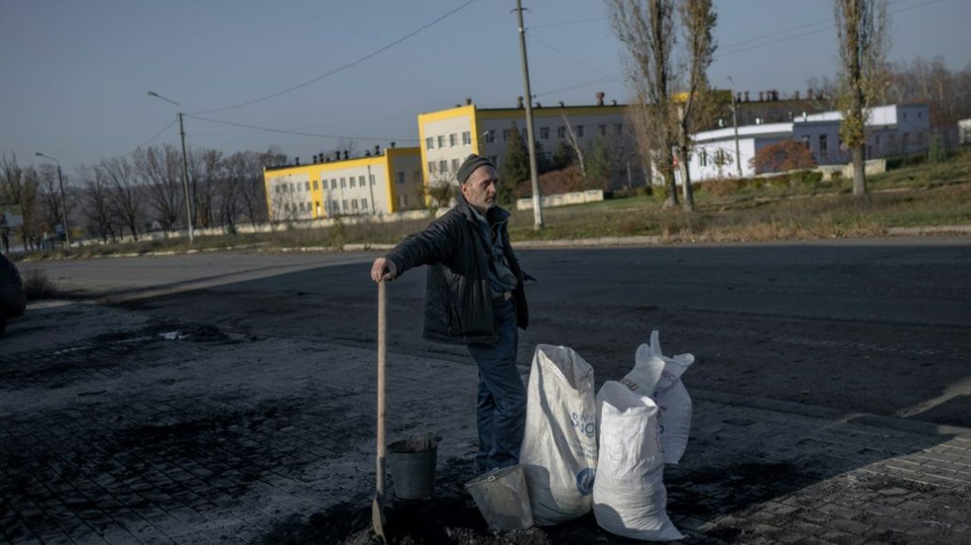 Un habitant à côté de sacs remplis de charbon à la périphérie de Bakhmout, le 9 novembre 2022 en Ukraine.