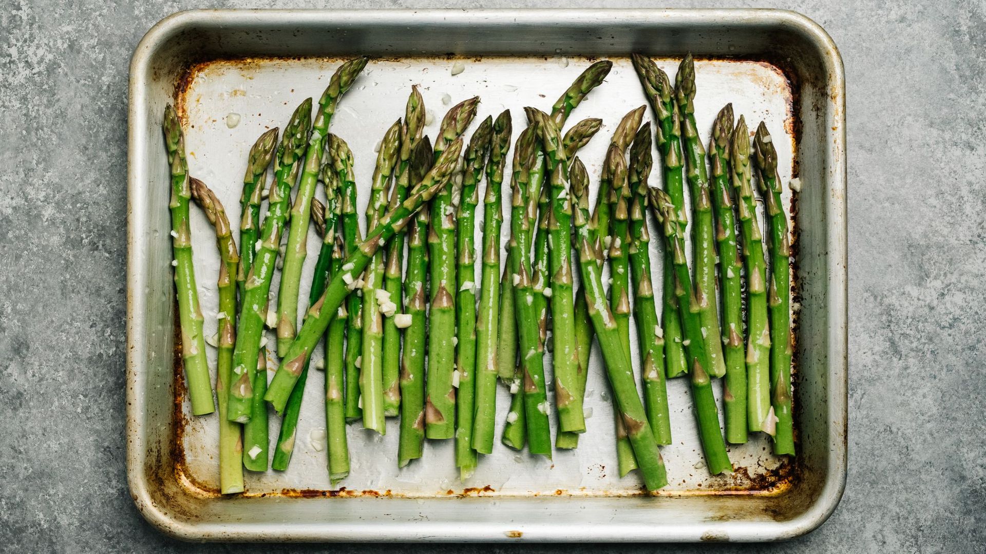 Oiled asparagus on a baking sheet