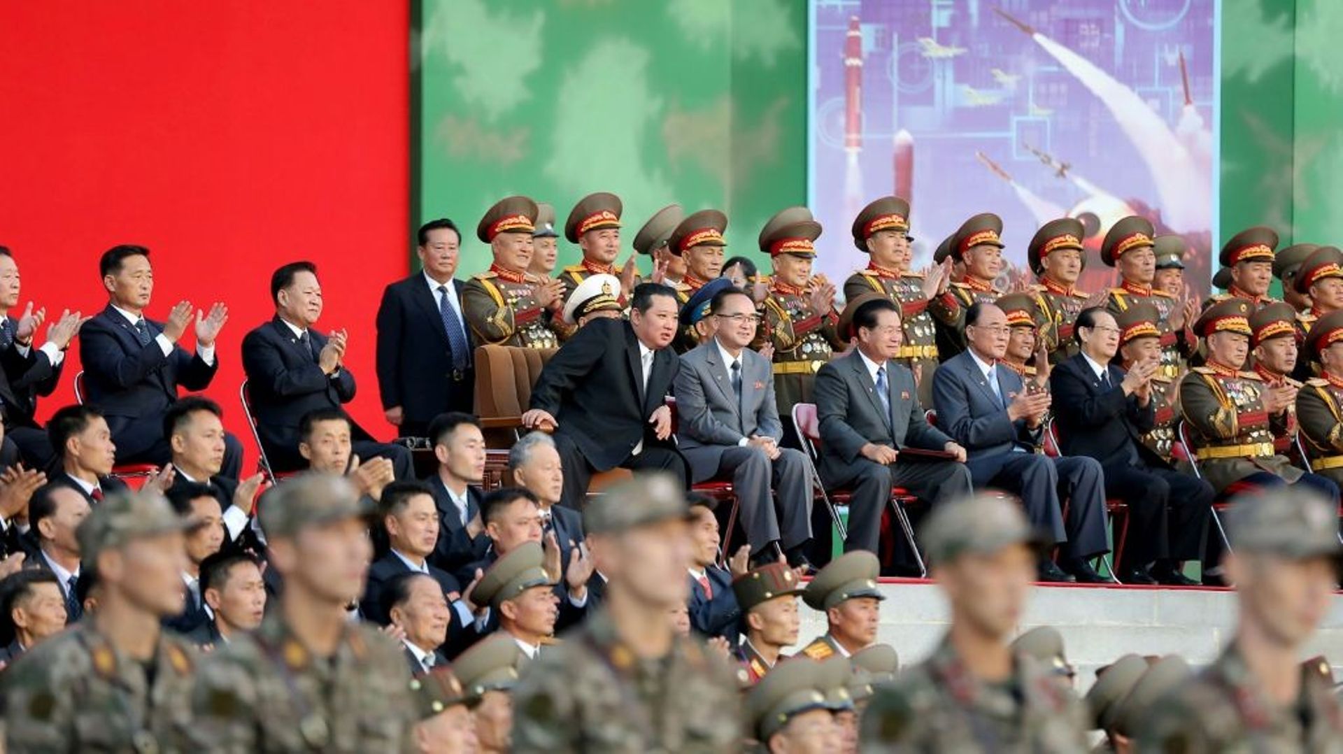 Photo diffusée par l’agence nord-coréenne Kcna, le 12 octobre 2021, du leader nord-coréen Kim Jong Un (c, g) à l’ouverture de l’exposition "Auto-défense 2021" à Pyongyang