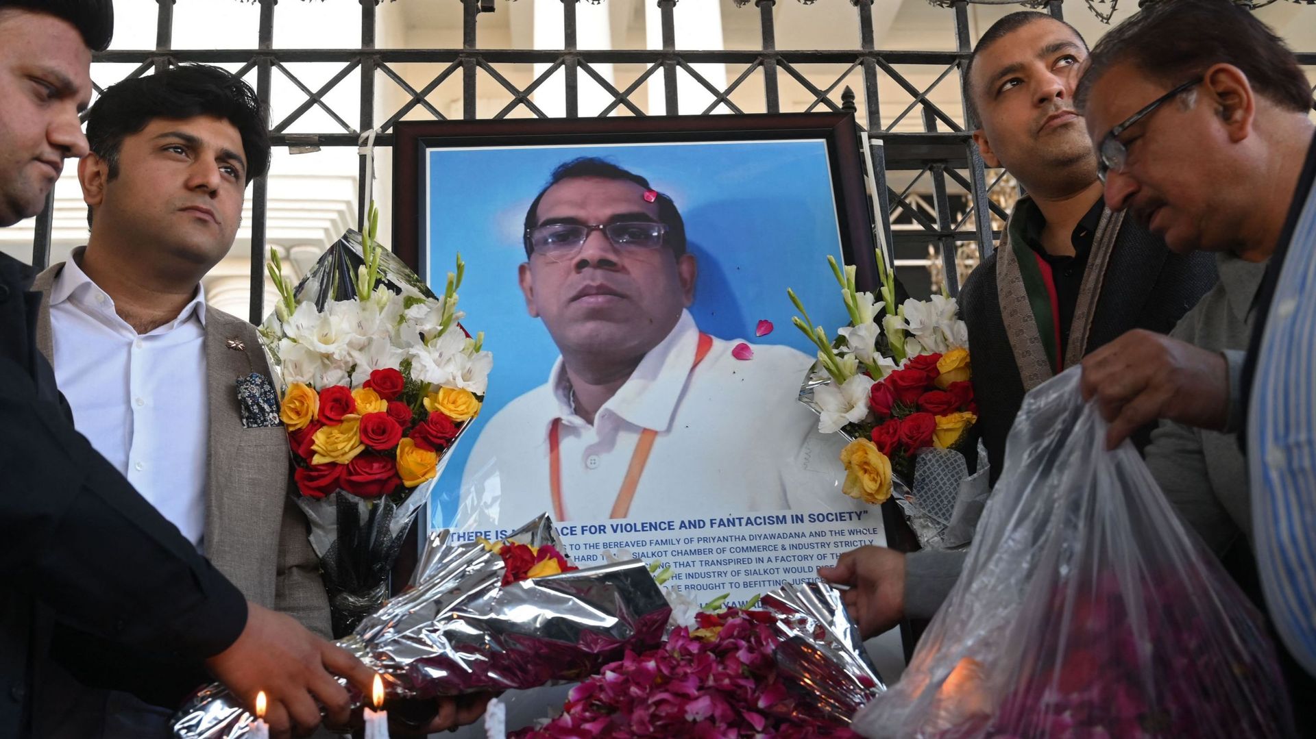 Des industriels pakistanais rendent hommage à côté d’une photo du directeur d’usine sri-lankais décédé, à Sialkot, le 4 décembre 2021, après qu’il ait été battu à mort et incendié par une foule qui l’accusait de blasphème, selon des responsables.