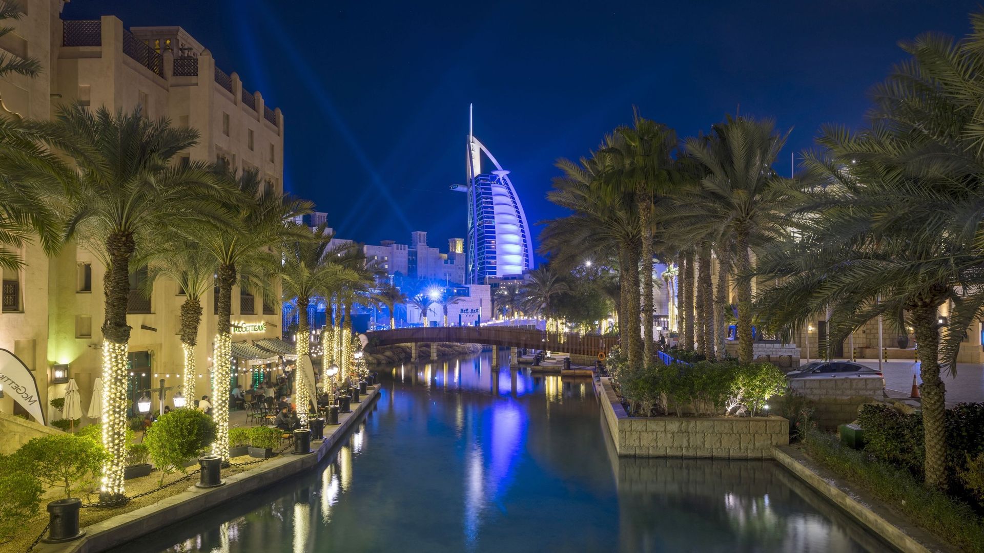 Le Burj al Arab est illuminé par des faisceaux de lumière dans le Souk Madinat Jumeirah.