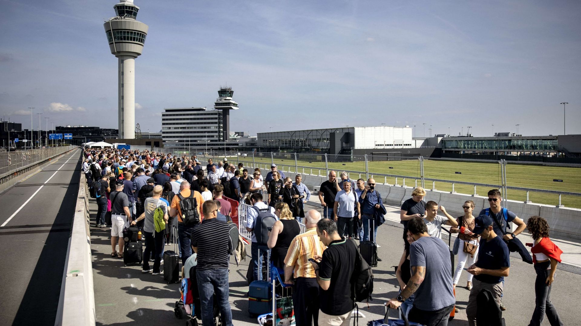 Des voyageurs font la queue à l'aéroport de Schiphol, le 12 septembre 2022, après que l'aéroport  a demandé à plusieurs compagnies aériennes d'annuler des vols en raison d'une pénurie de personnel de sécurité.