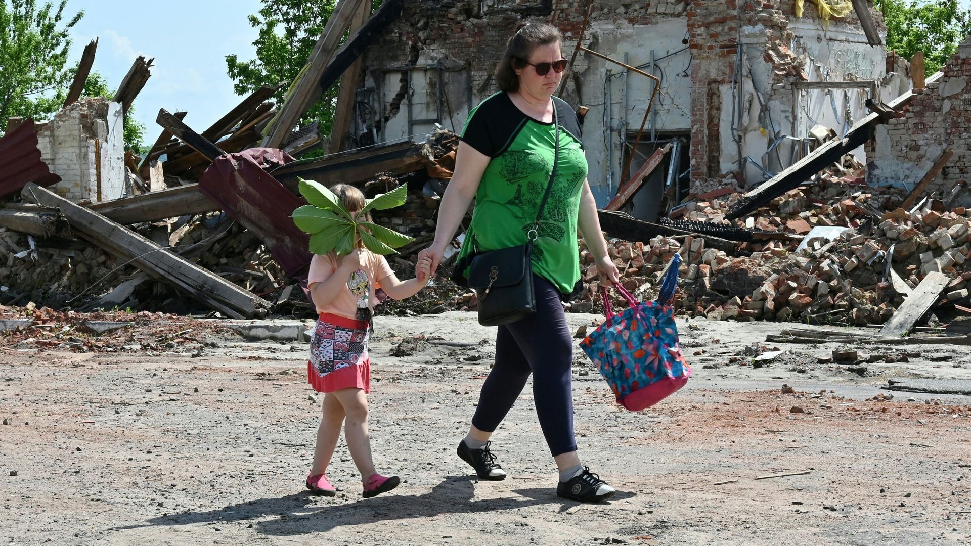 Des habitants passent devant un bâtiment détruit par les bombardements dans le centre de Kupiansk, dans la région de Kharkiv, le 26 mai 2023, lors de l’invasion russe de l’Ukraine.