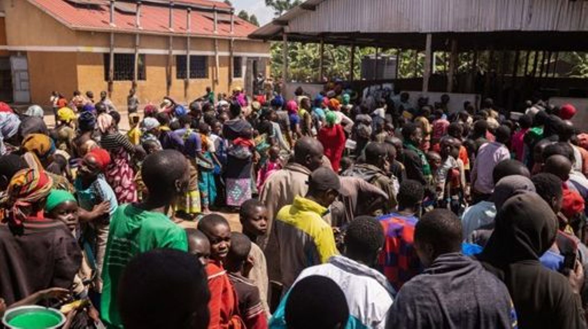 Refugees from the Democratic Republic of Congo (DRC) wait in lines for receiving lunch at the Nyakabande Transit Center in Kisoro, Uganda, June 7, 2022, following deadly fights between M23 rebels, one of more than 120 armed groups roaming eastern DRC, and