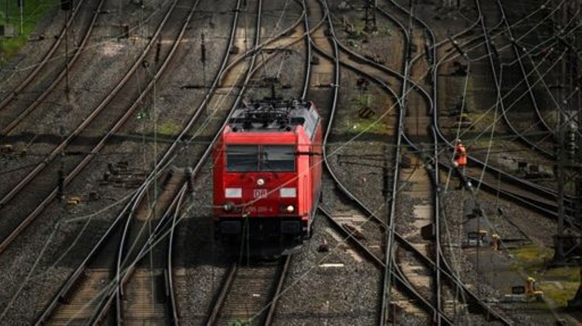 A worker walks past a locomotive on train tracks of German railway operator Deutsche Bahn at the railway freight station in Hagen, western Germany, on March 24, 2023. Transport across much of Germany will be paralysed on Monday, March 27, 2023, as workers