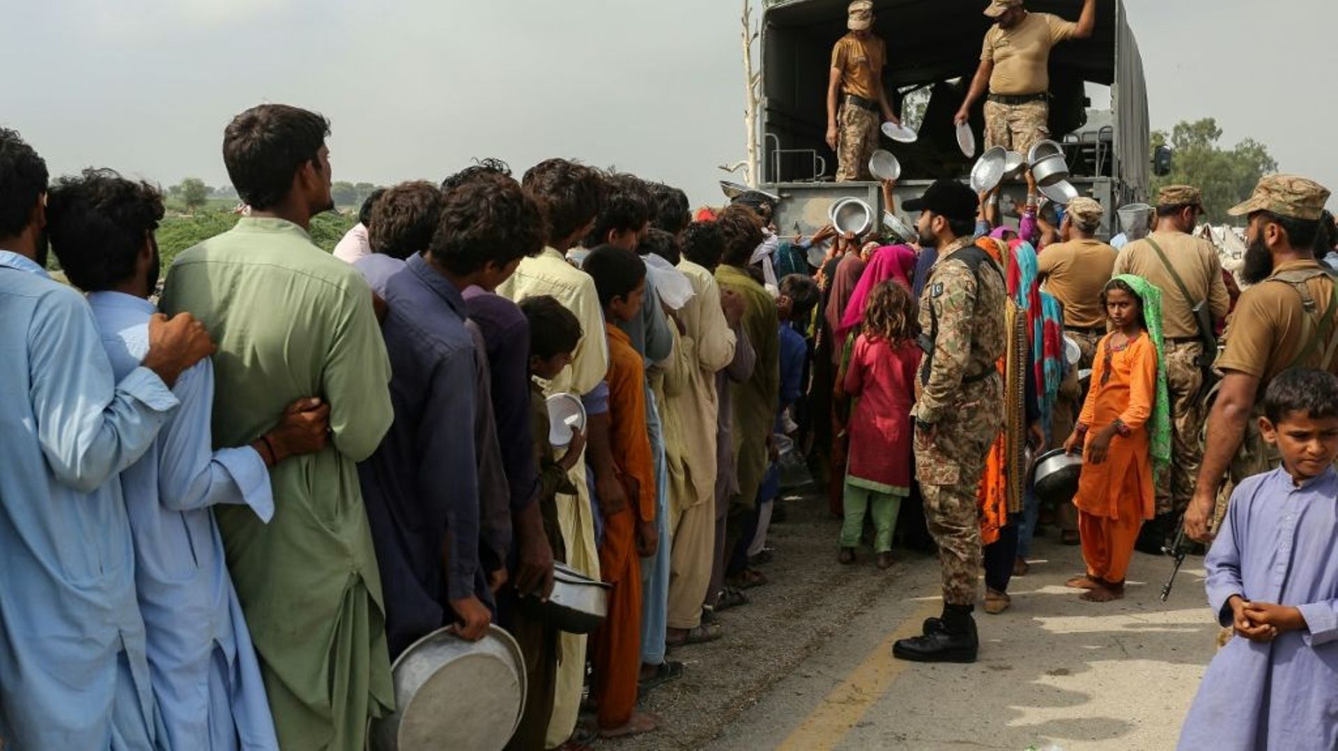 Des militaires procèdent à une distribution de nourriture pour des sinistrés après de violentes pluies de mousson, le 27 août 2022 à Rajanpur (Pakistan)