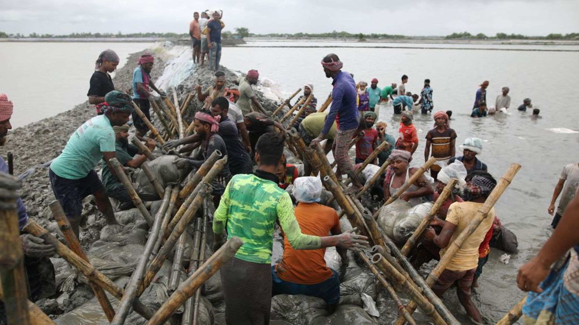 13 août à Khulna, Bangladesh : les habitants réparent les remblais endommagés par la marée haute. Cette eau salée ravage les cultures de l'intérieur des terres.
