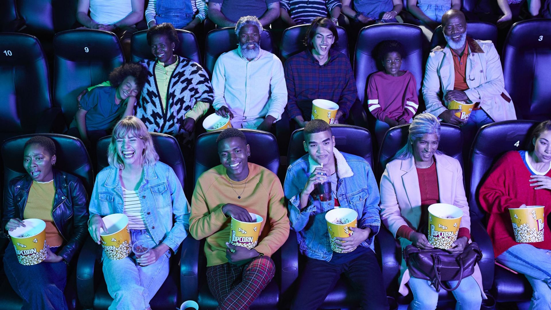 Spectateurs dans une salle de cinéma mangeant du pop-corn.