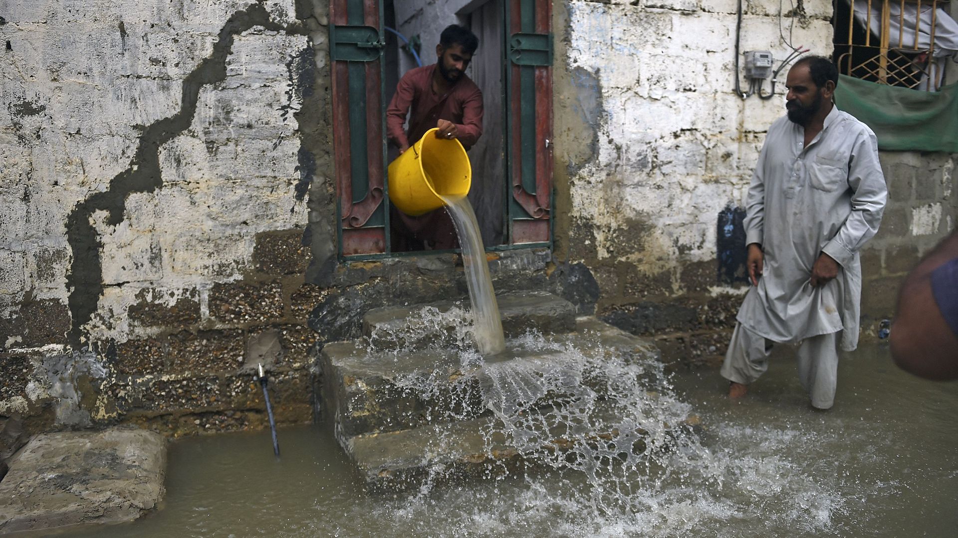 Un habitant utilise un seau pour retirer l’eau de sa maison inondée après de fortes pluies de mousson à Karachi, le 26 juillet 2022.