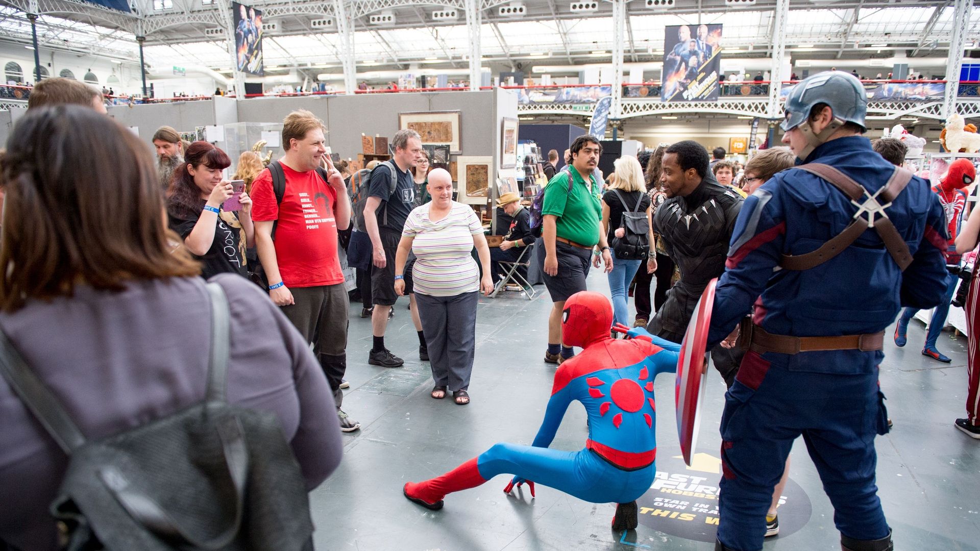 Des cosplayers Avengers en personnage de Sipder Man, Black Panther et Captain America posent pour des photos avec le public lors du London Film and Comic Con 2019 à l’Olympia London le 27 juillet 2019 à Londres, en Angleterre.