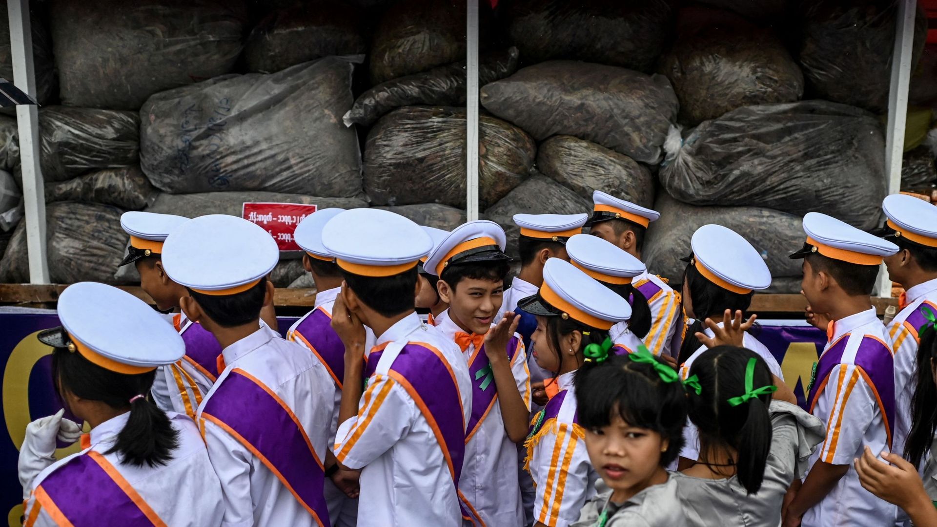 Des étudiants regardent une pile de drogues illégales saisies avant d'y mettre le feu lors d'une cérémonie de destruction organisée à l'occasion de la Journée internationale contre l'abus et le trafic de drogues des Nations unies, à Yangon, le 26 juin 202