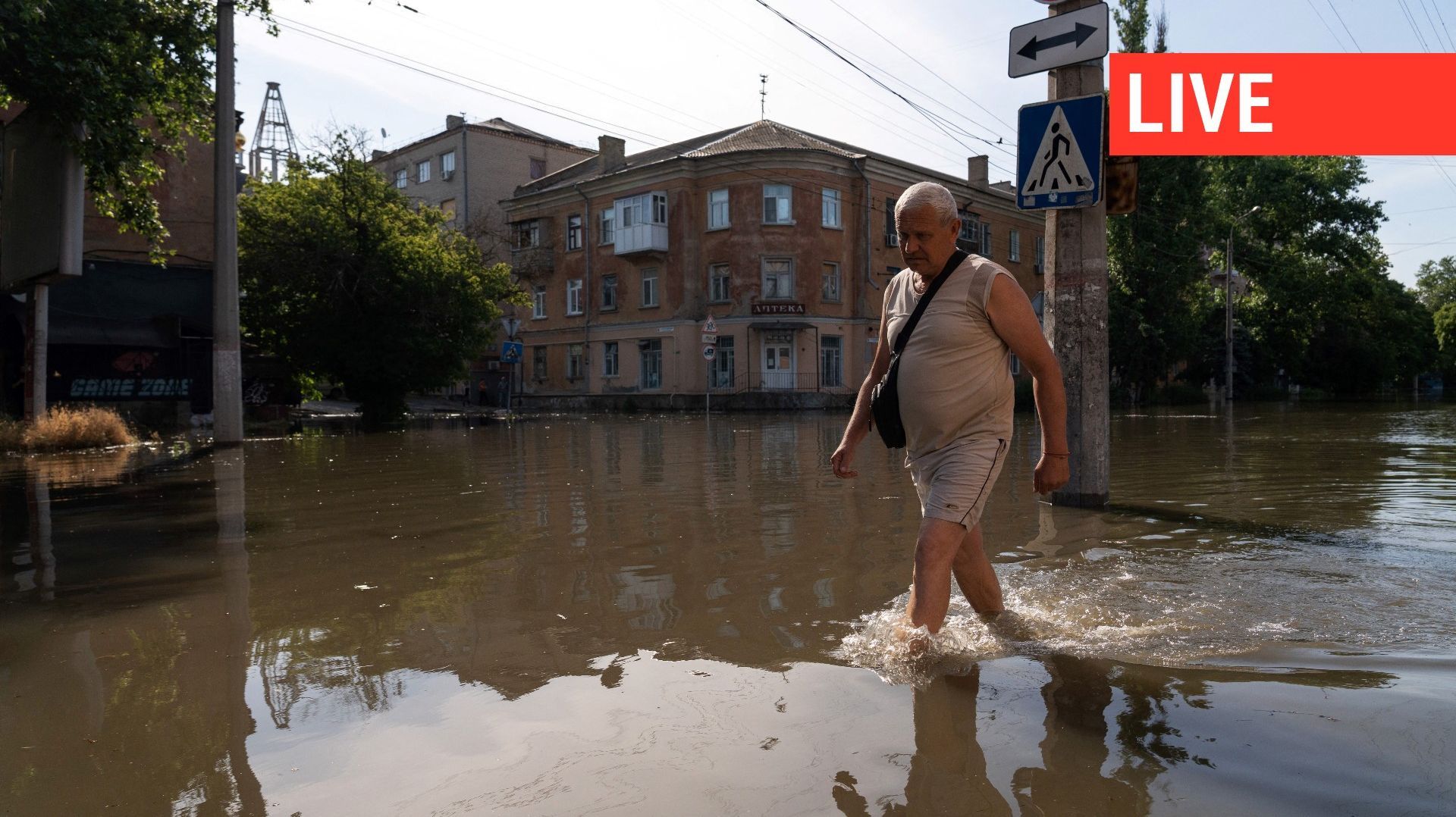 Un habitant de Kherson marche le long d’une rue inondée le 7 juin 2023, suite aux dommages subis par le barrage de la centrale hydroélectrique de Kakhovka.