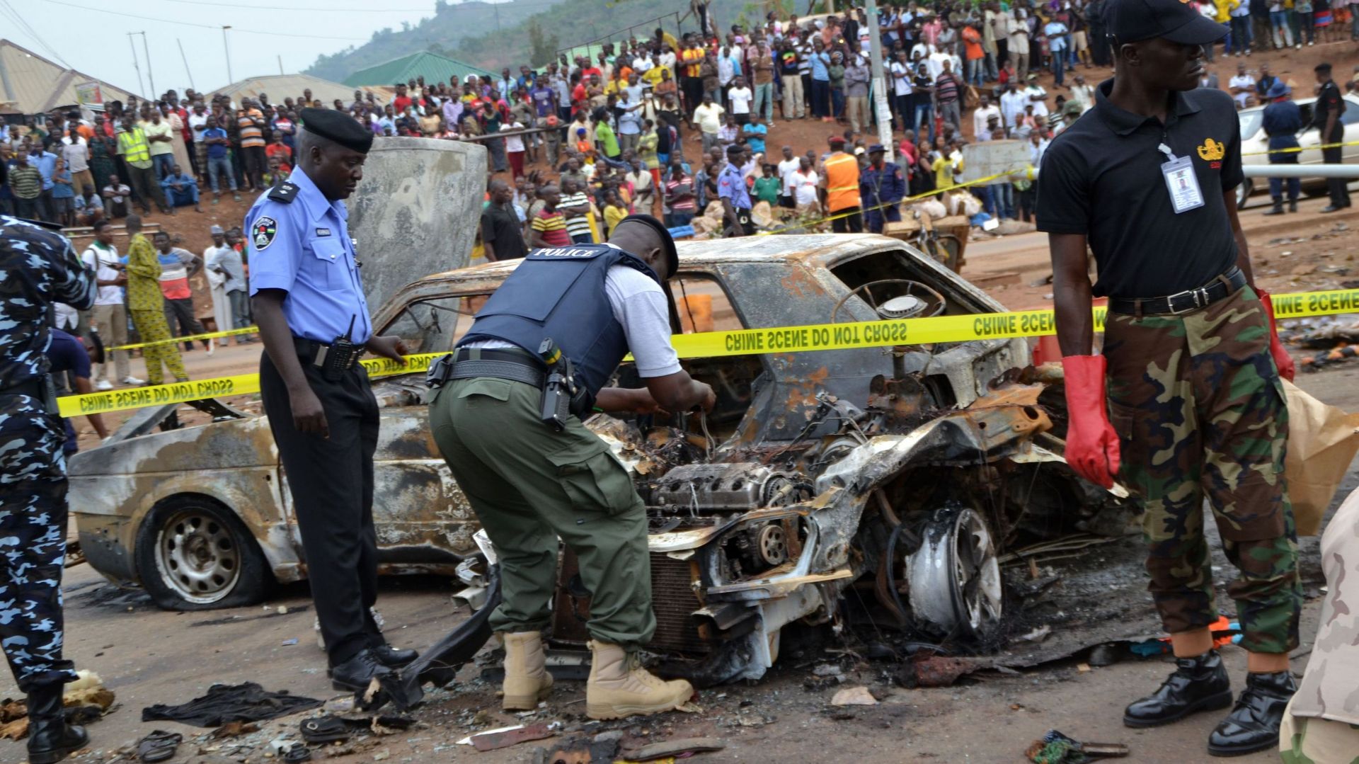 Des membres des servces de sécurité examinent le site de l'attentat d'Abuja le 2 mai 